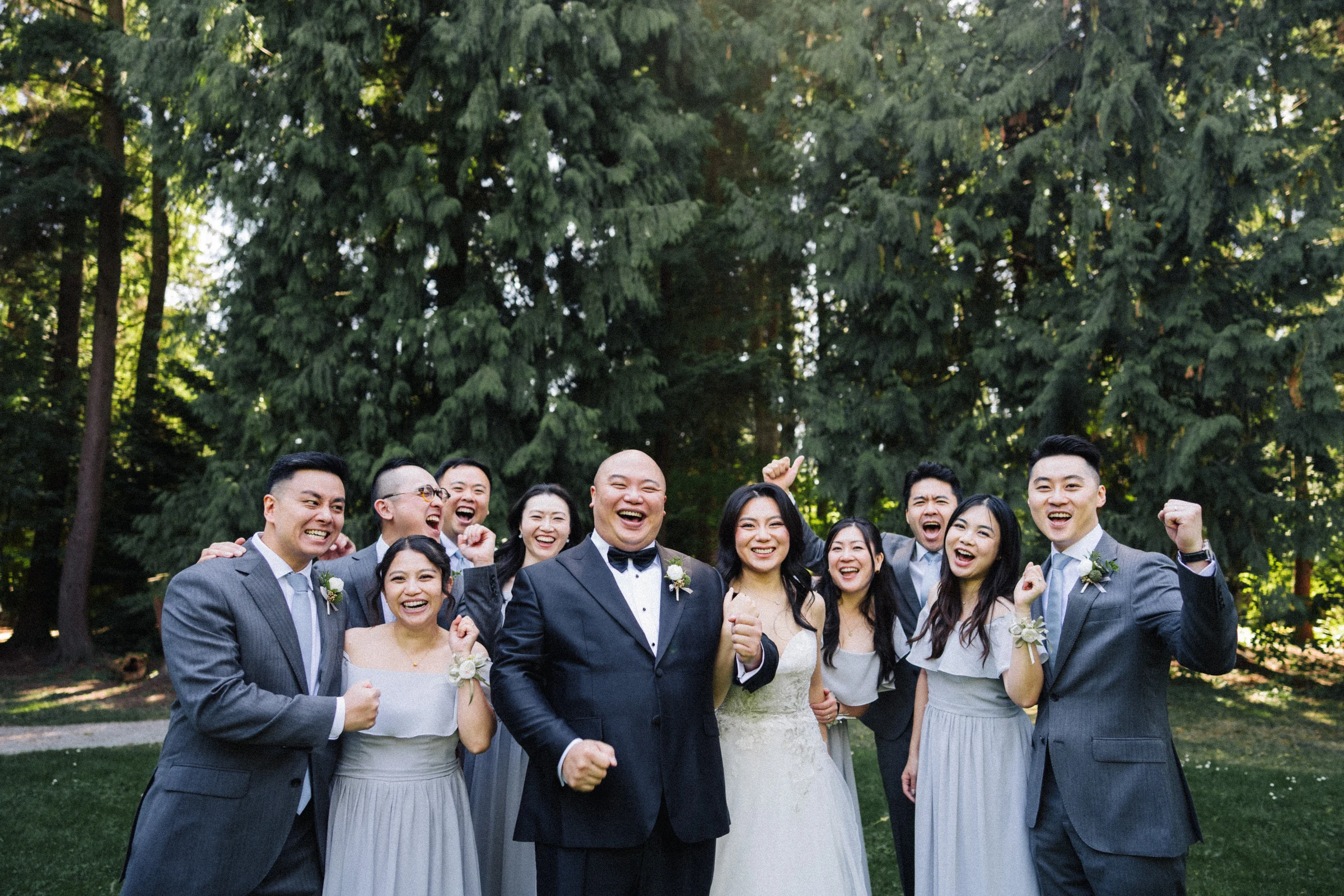 Wedding party gathered closely for a smiling group portrait.