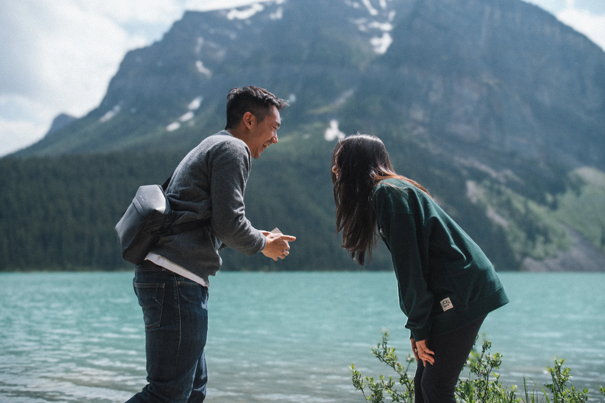 Rachael and Desmond laugh together beside Lake Louise in Banff National Park after the proposal.