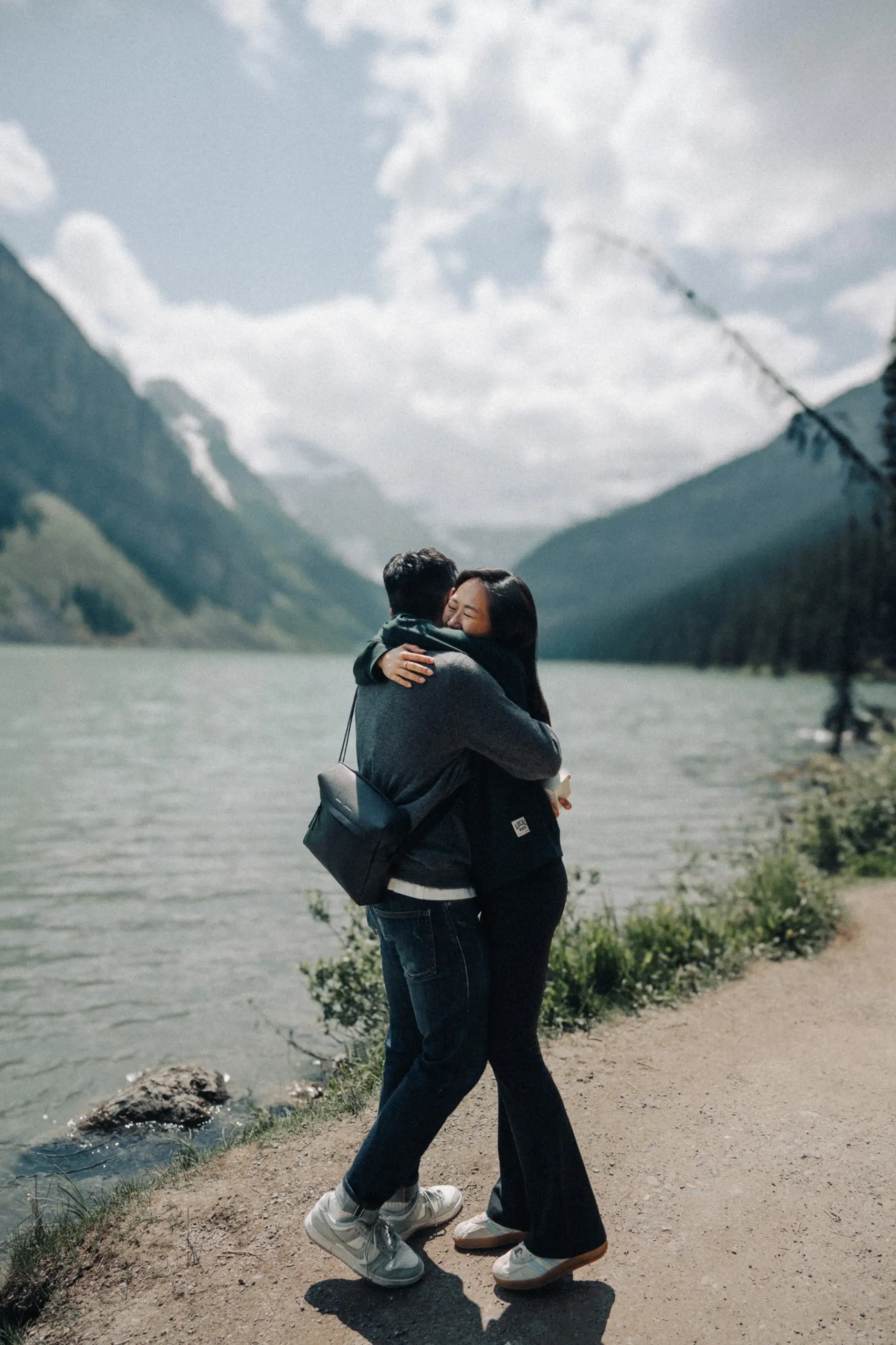 Full-length view of Rachael and Desmond embracing on the path beside Lake Louise in Banff National Park.