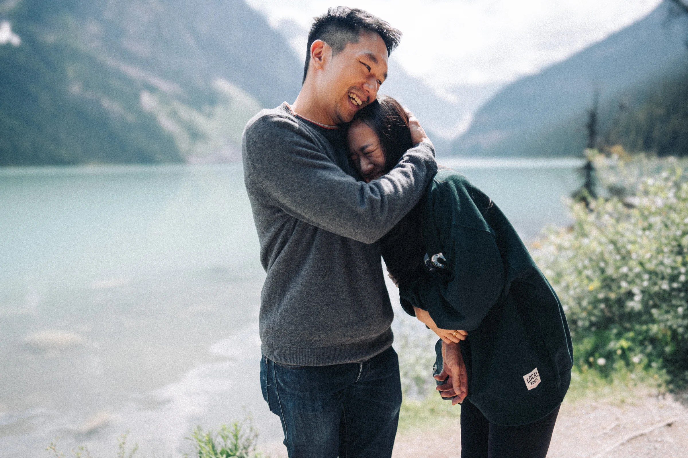 Desmond embraces Rachael as she leans against him beside Lake Louise in Banff National Park.
