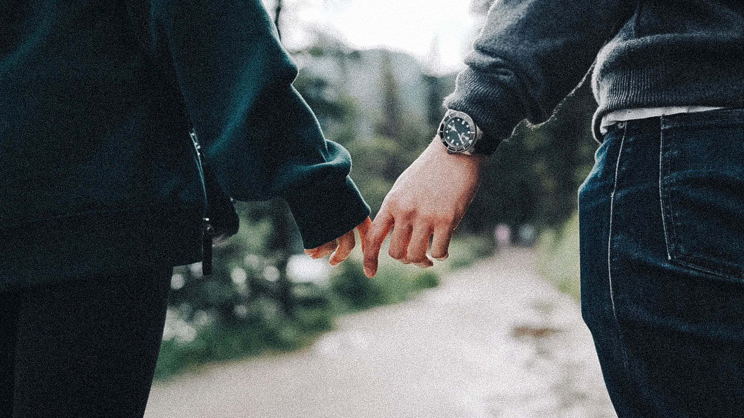 Close view of Rachael and Desmond linking fingers on a path at Lake Louise in Banff National Park.