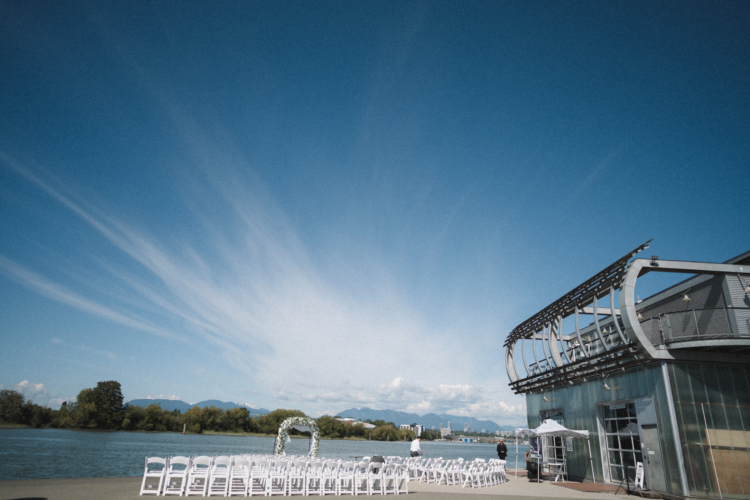 Wide view of the UBC Boathouse ceremony deck beneath a blue sky.