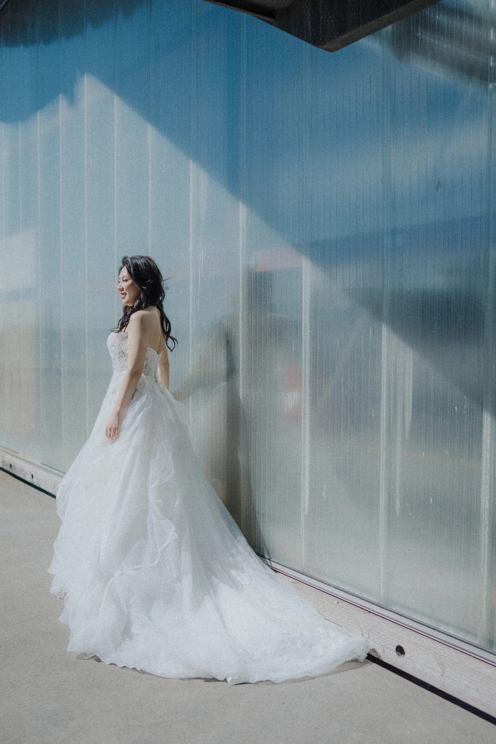 Bride standing against the translucent wall at UBC Boathouse.