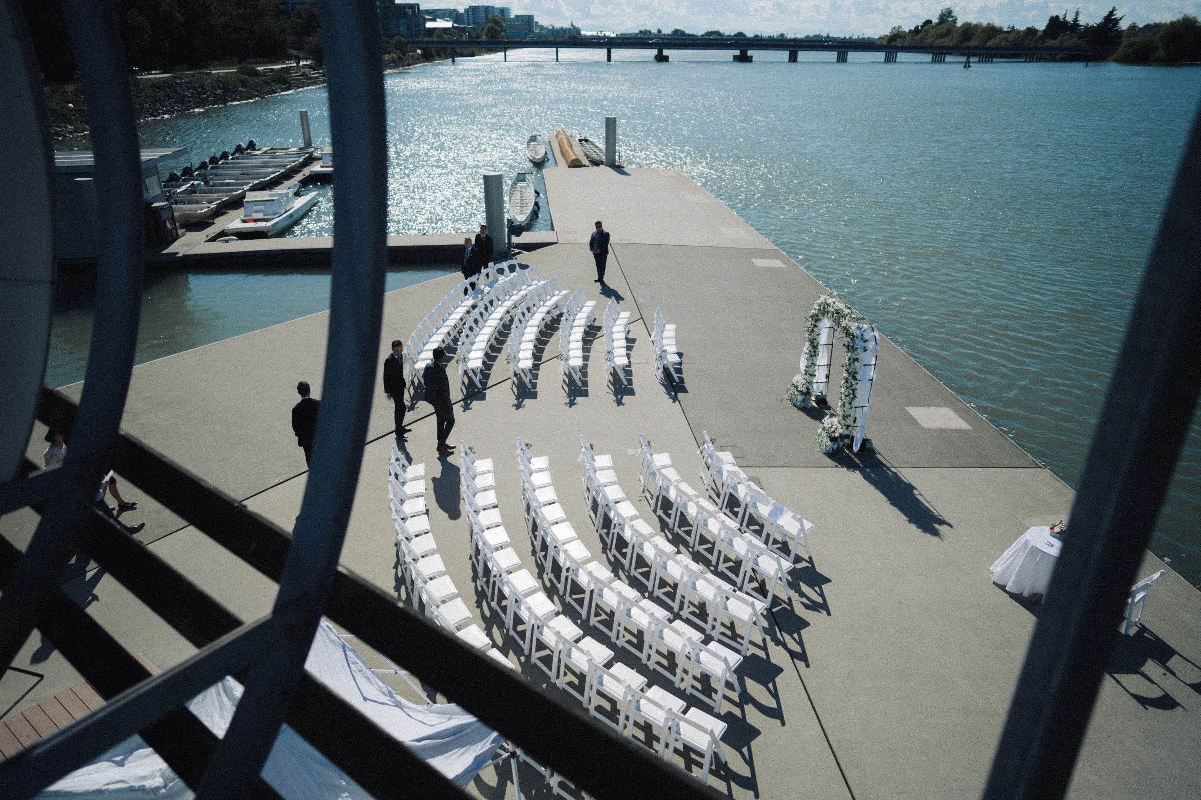 Overhead view of white ceremony chairs curving beside the river.