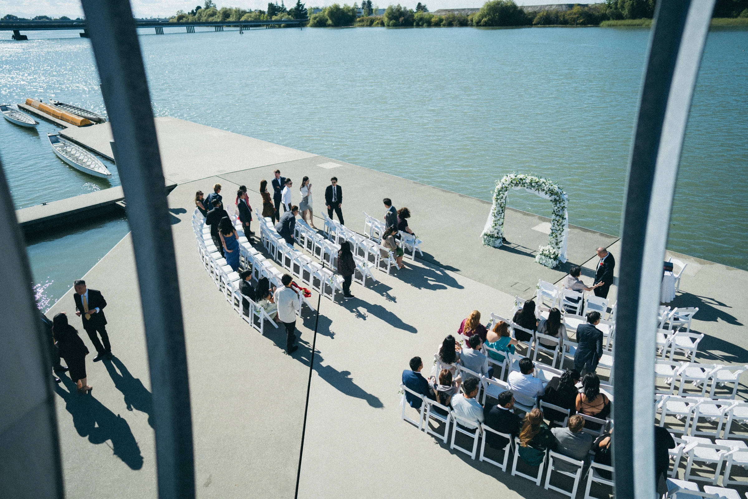 Elevated view of guests gathering beneath the ceremony arch.
