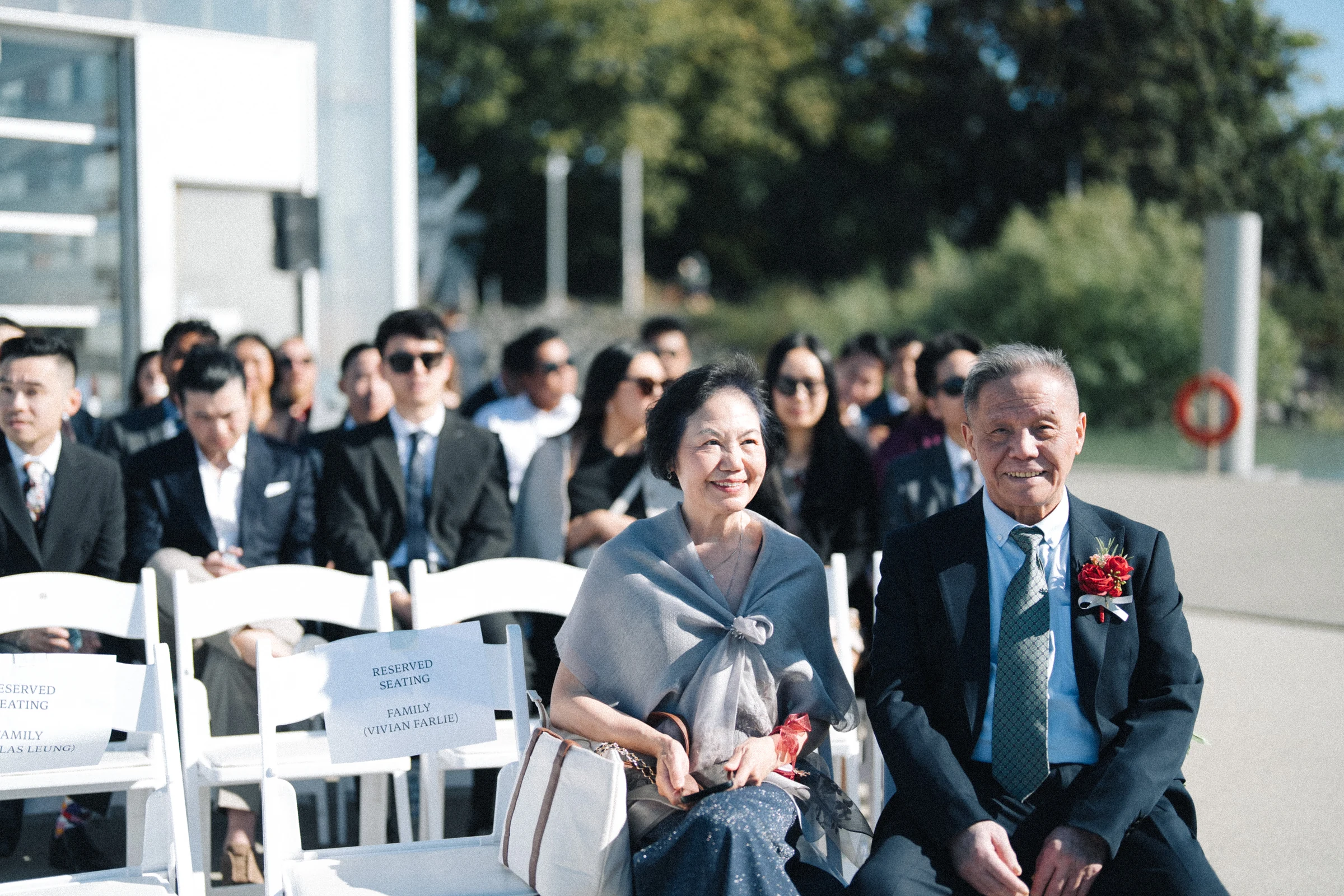 Two guests smiling from the front row of the ceremony seating.