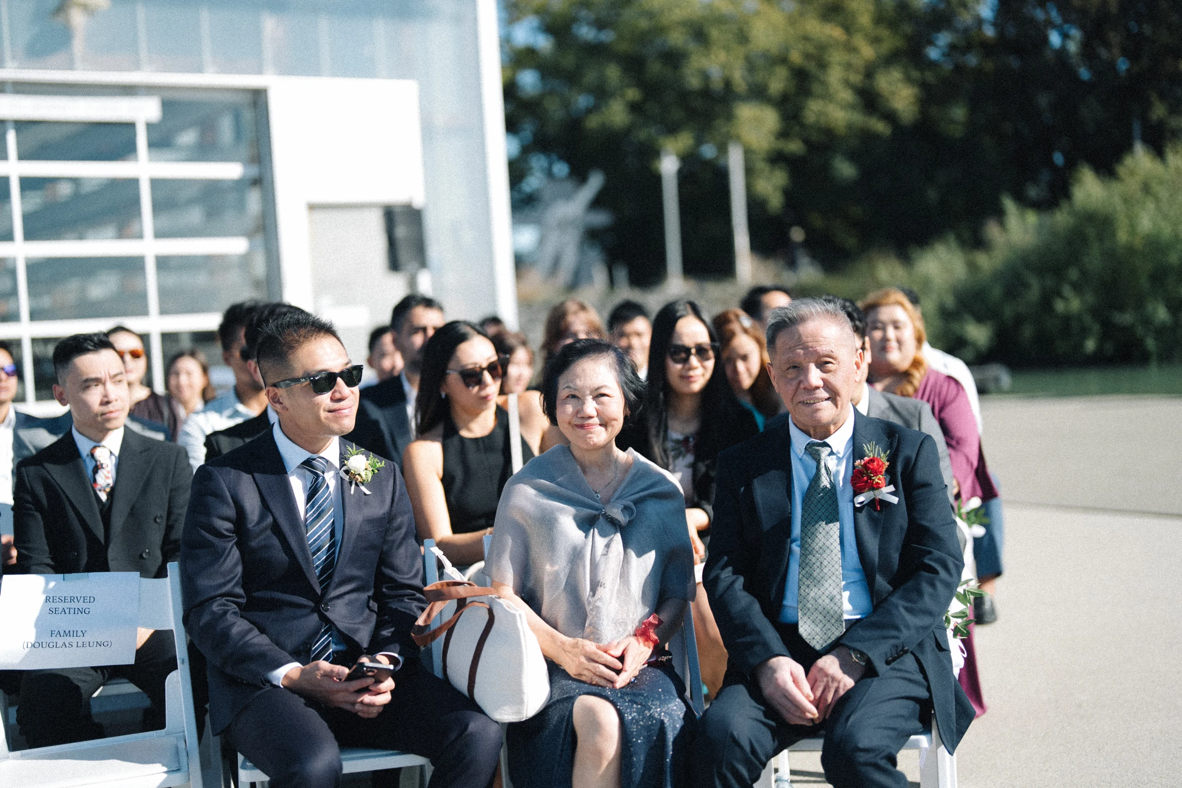 Front-row guests smiling towards the aisle.