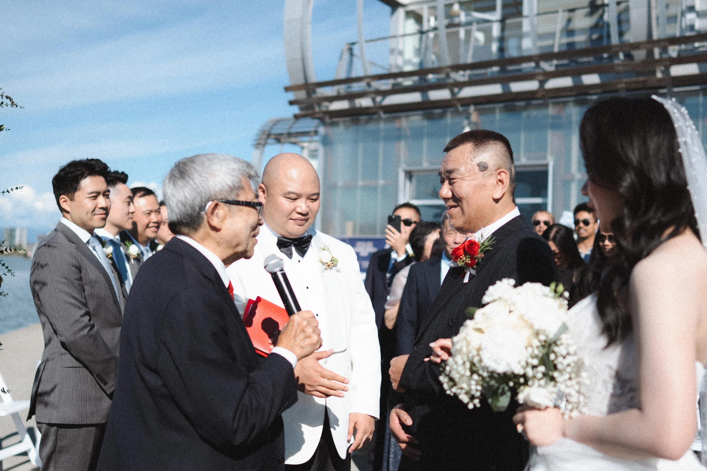 Couple greeting people beside the ceremony arch.