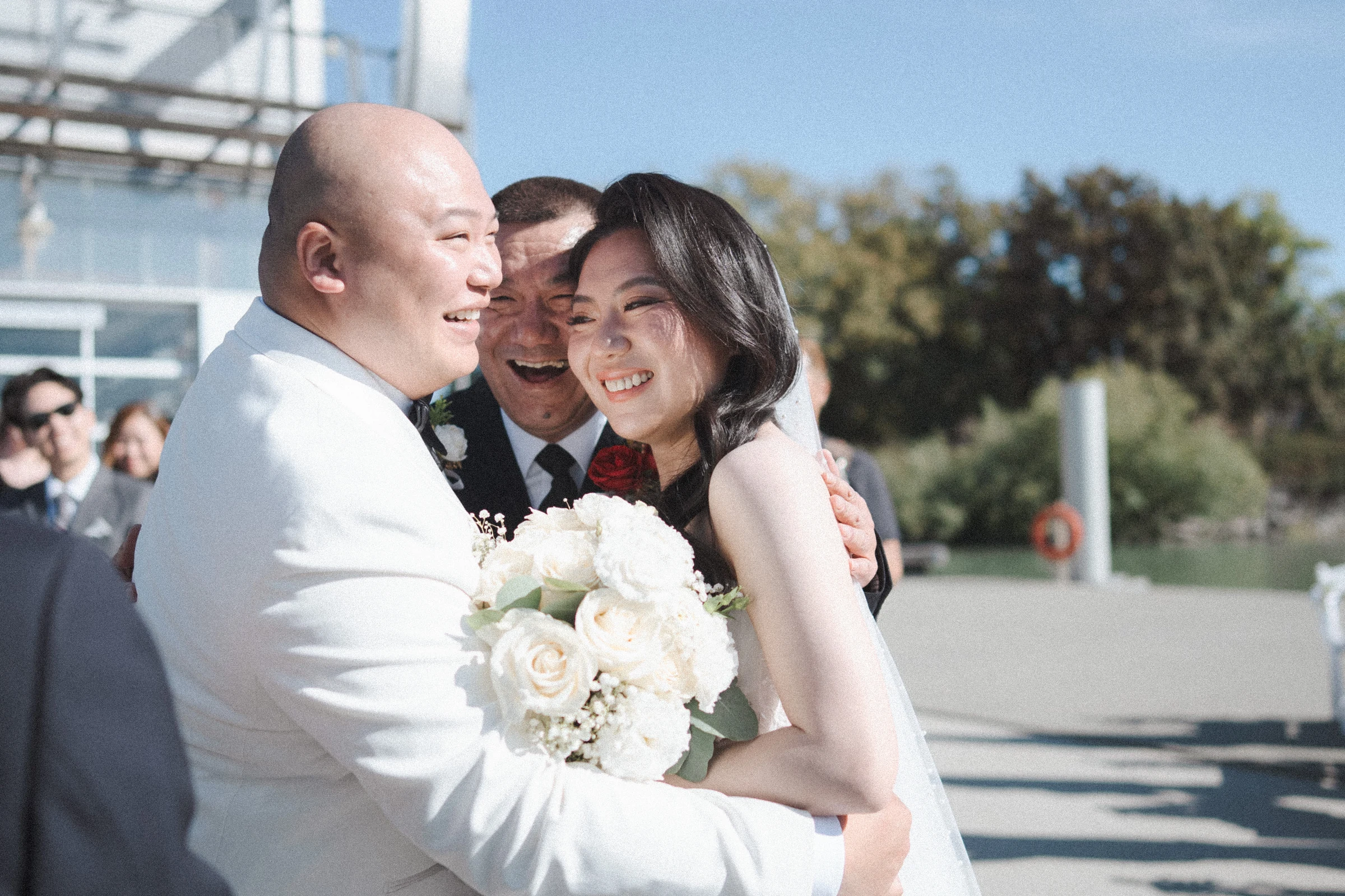 Bride and groom smiling as they embrace in front of the guests.