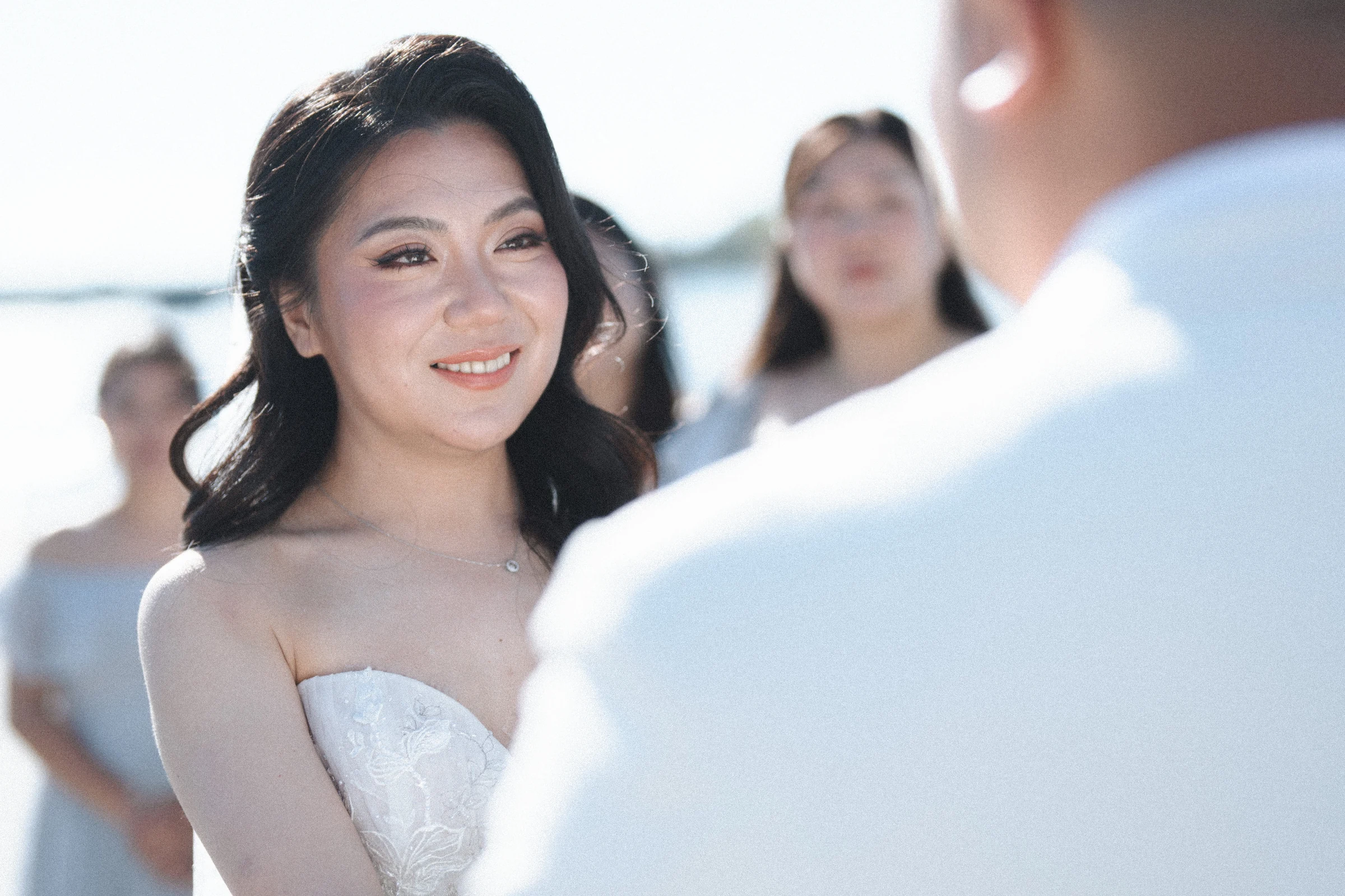 Bride smiling towards the groom during the ceremony.