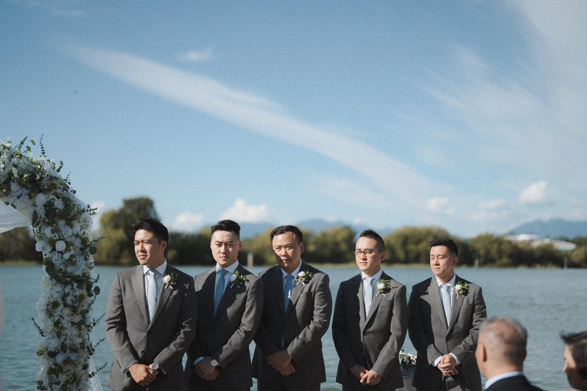 Groomsmen standing in a line beside the ceremony.