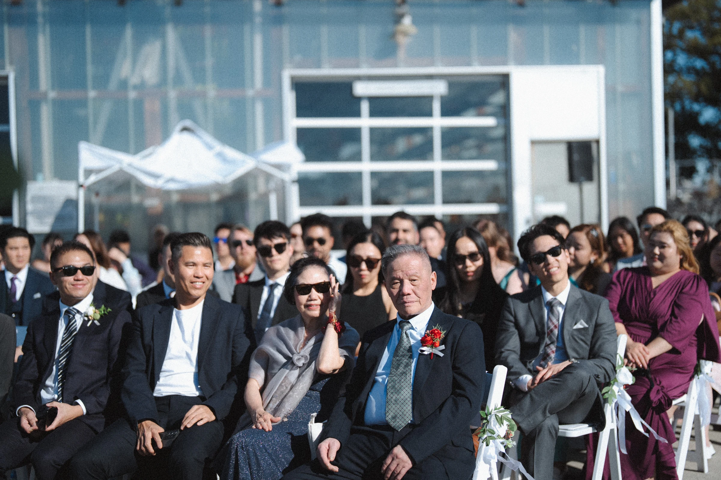 Guests seated in rows beside the boathouse.