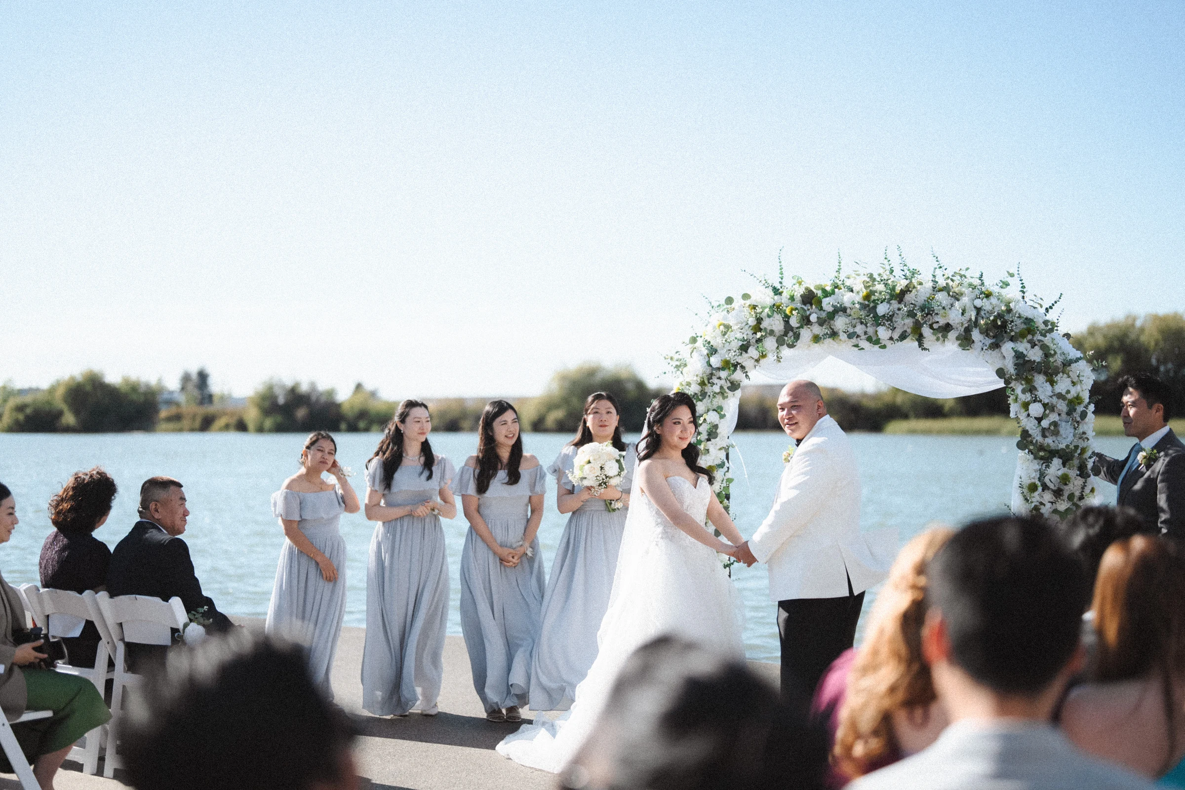 Bridal party smiling beside the couple after their vows.