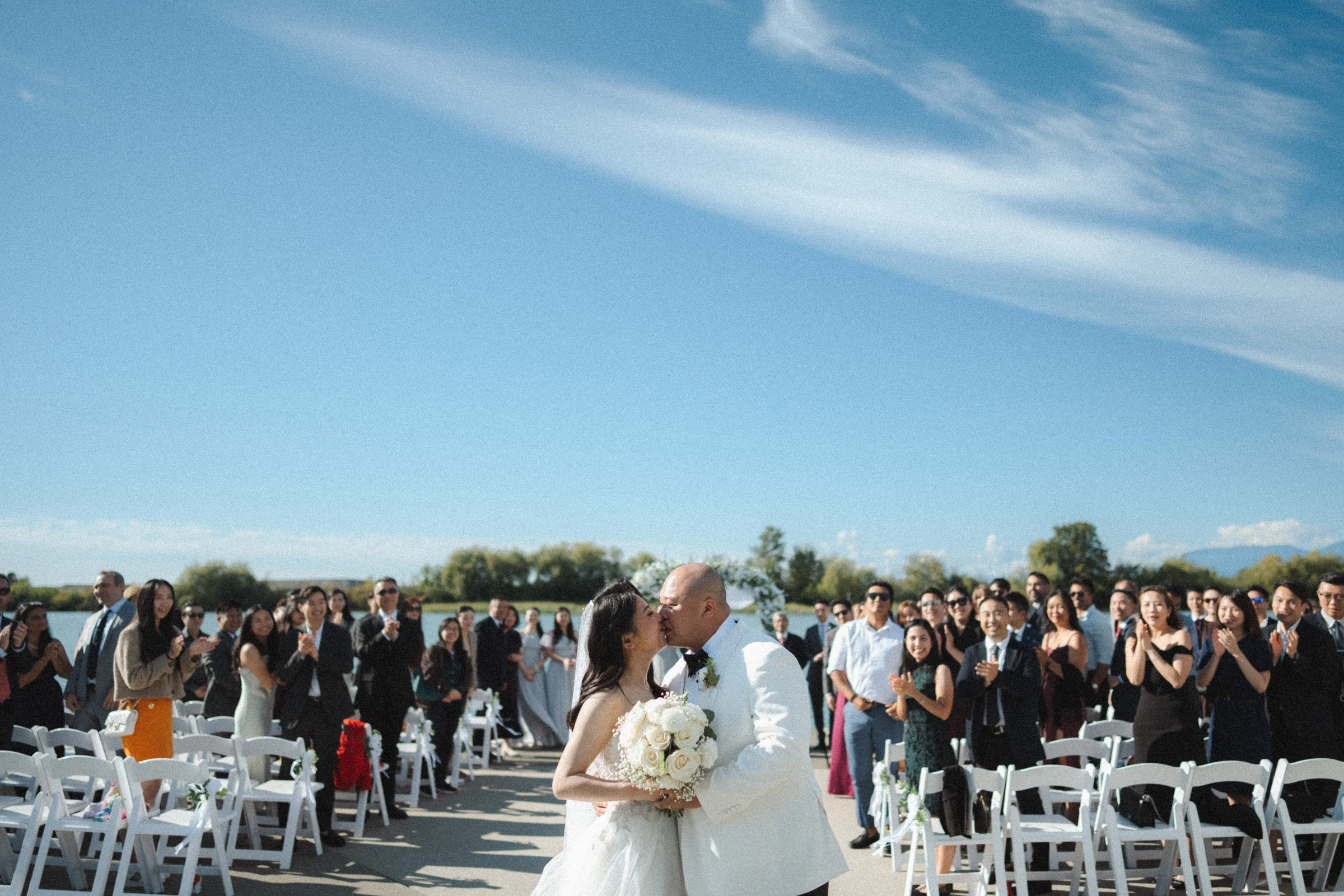 Bride and groom walking down the aisle with their guests behind them.