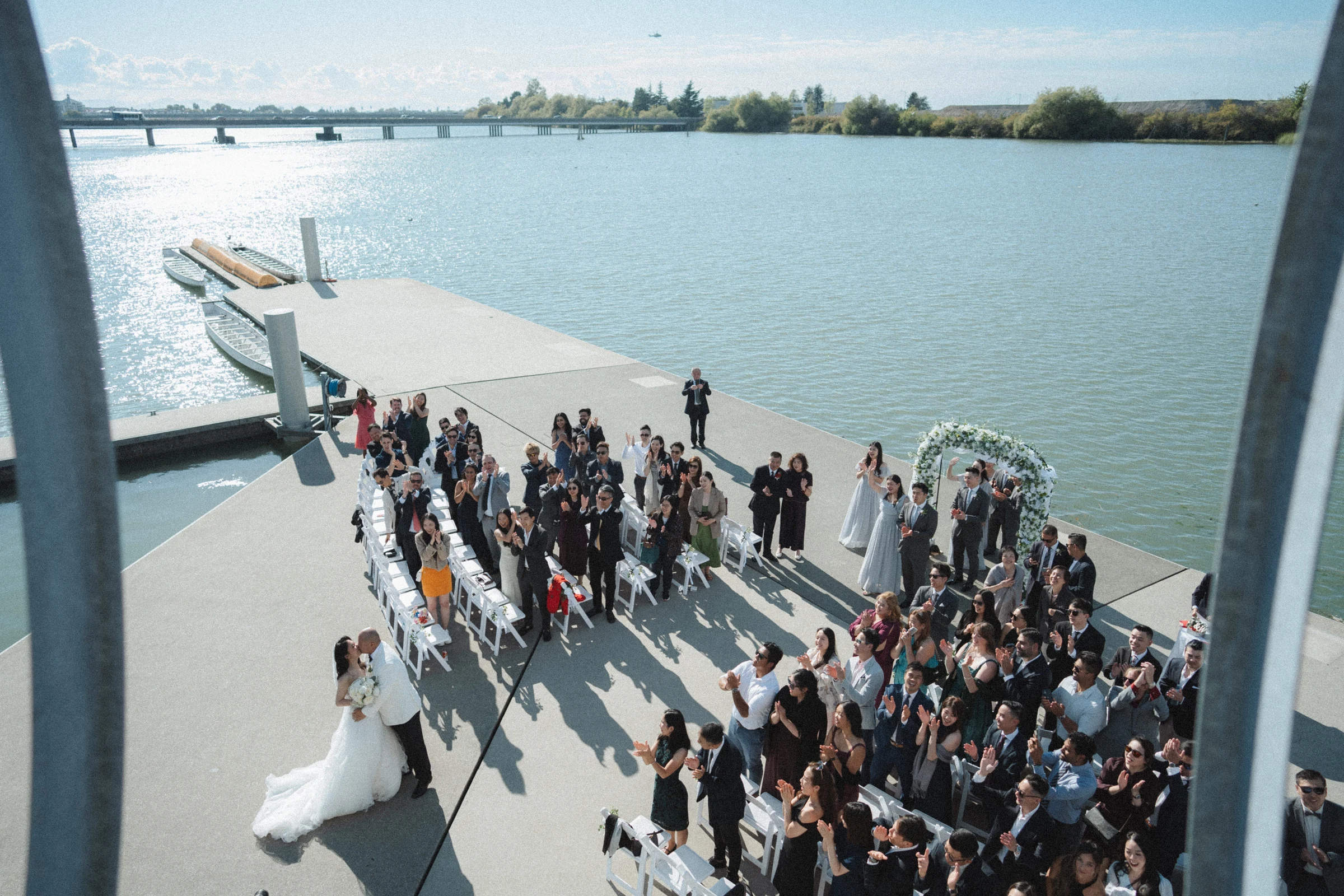 Elevated view of the newlyweds and assembled guests beside the river.