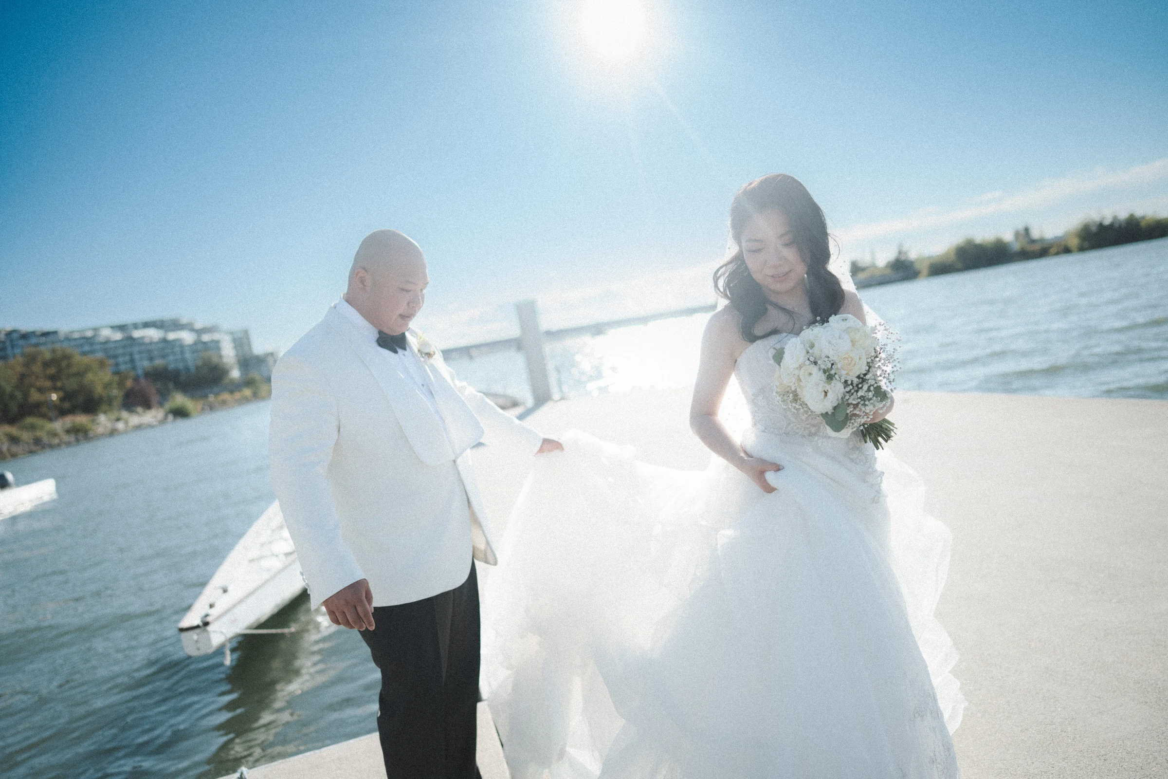 Couple walking together, with the bride lifting her wedding dress.