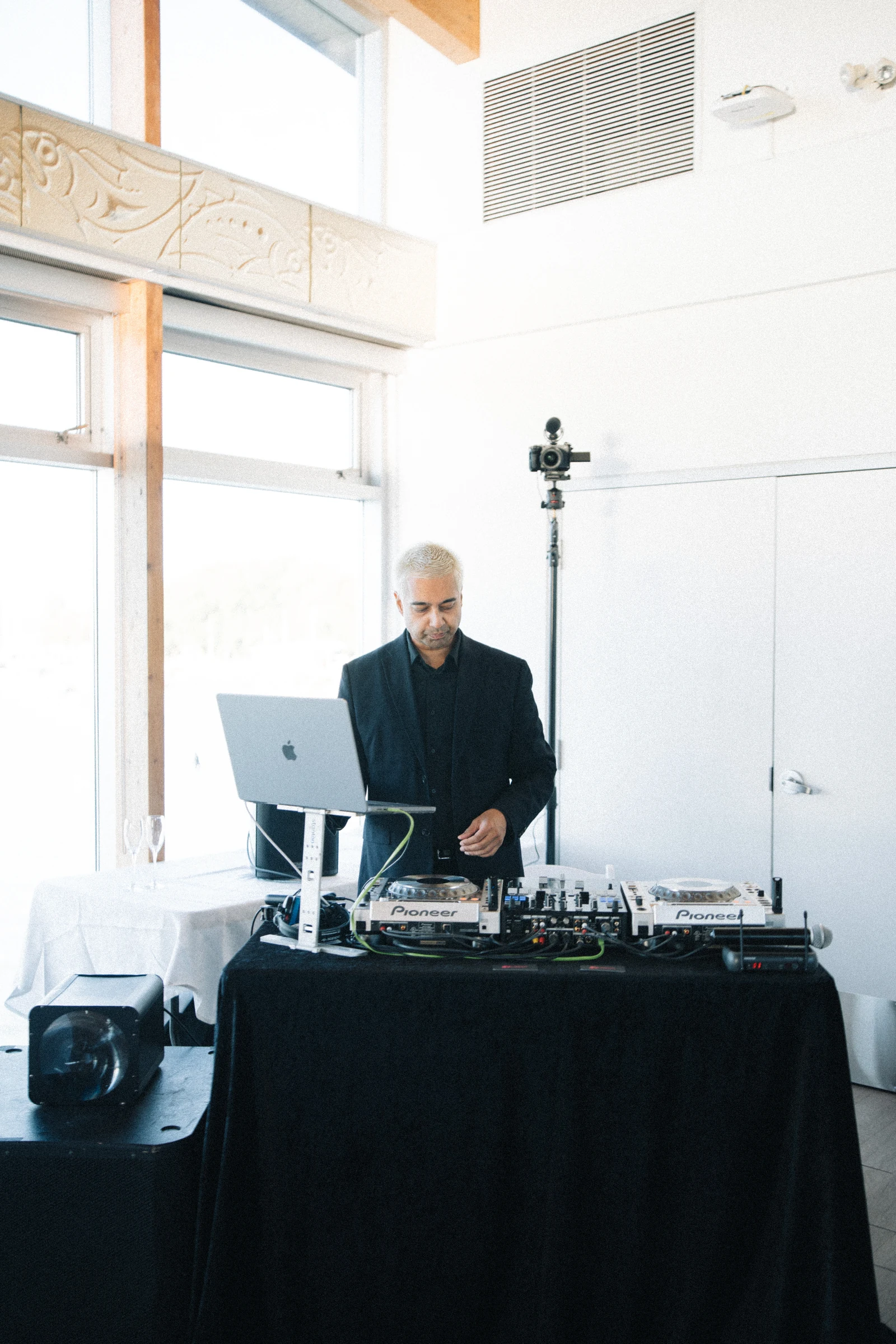 DJ standing behind the reception sound equipment.