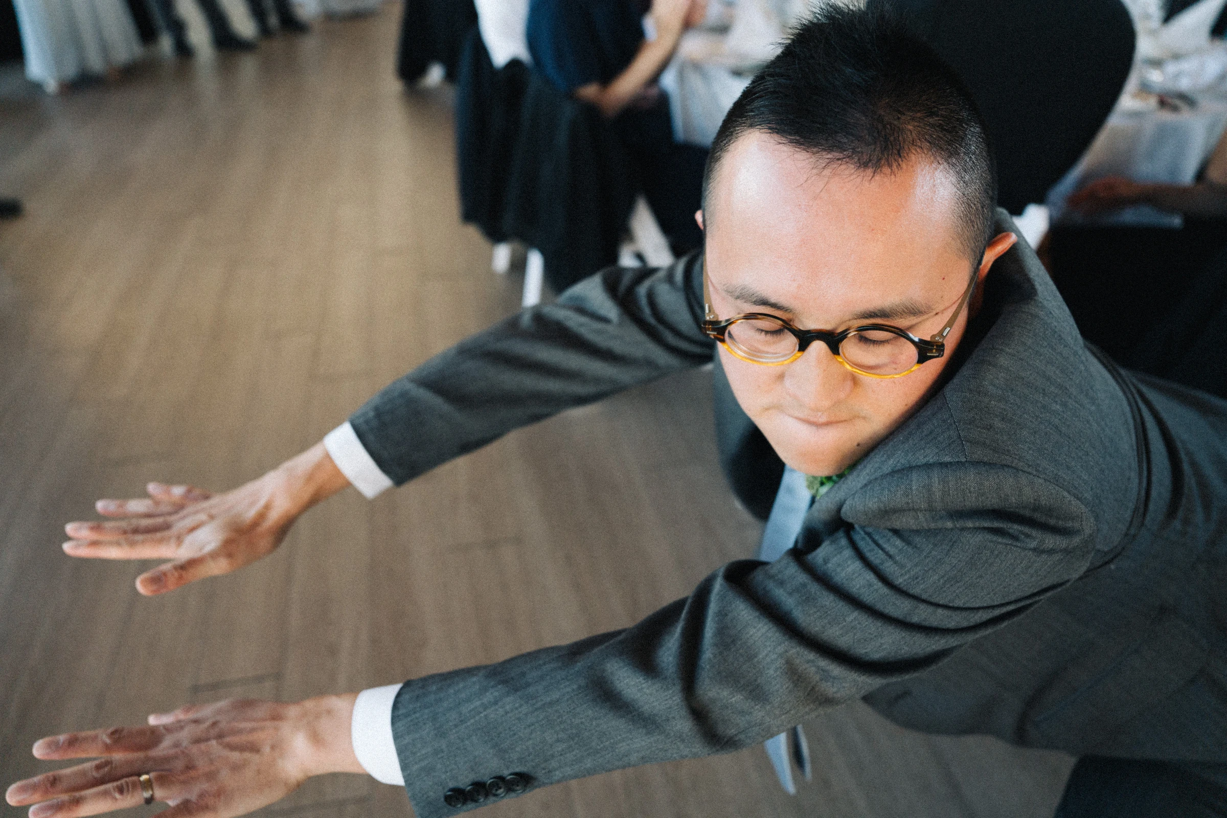 Guest dancing into the reception with his arms extended.