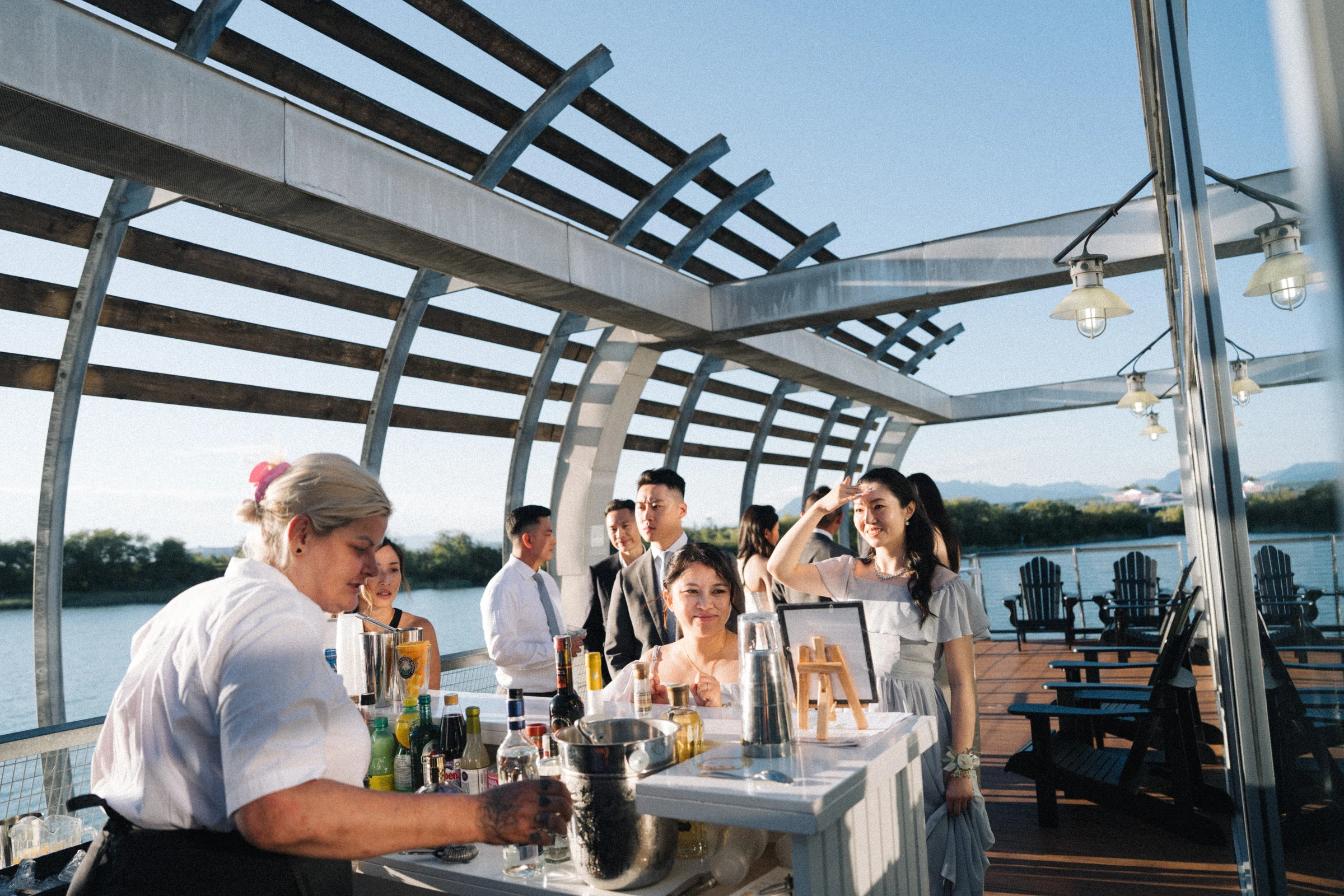 Guests sharing drinks on the covered boathouse terrace.