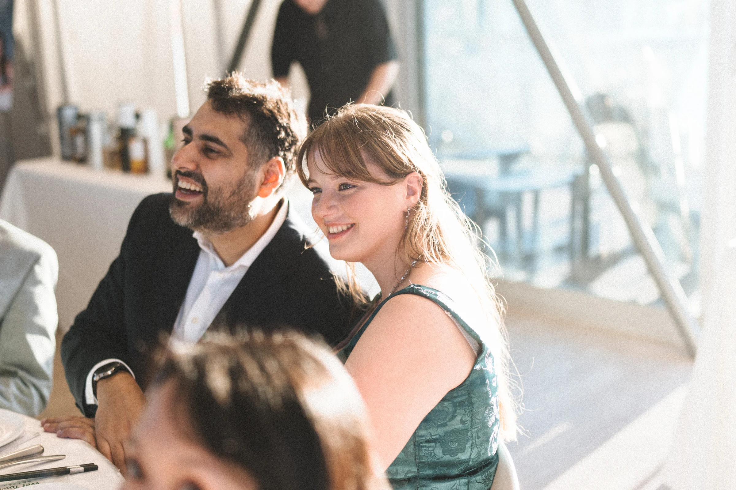 Guests smiling across a table inside the boathouse.