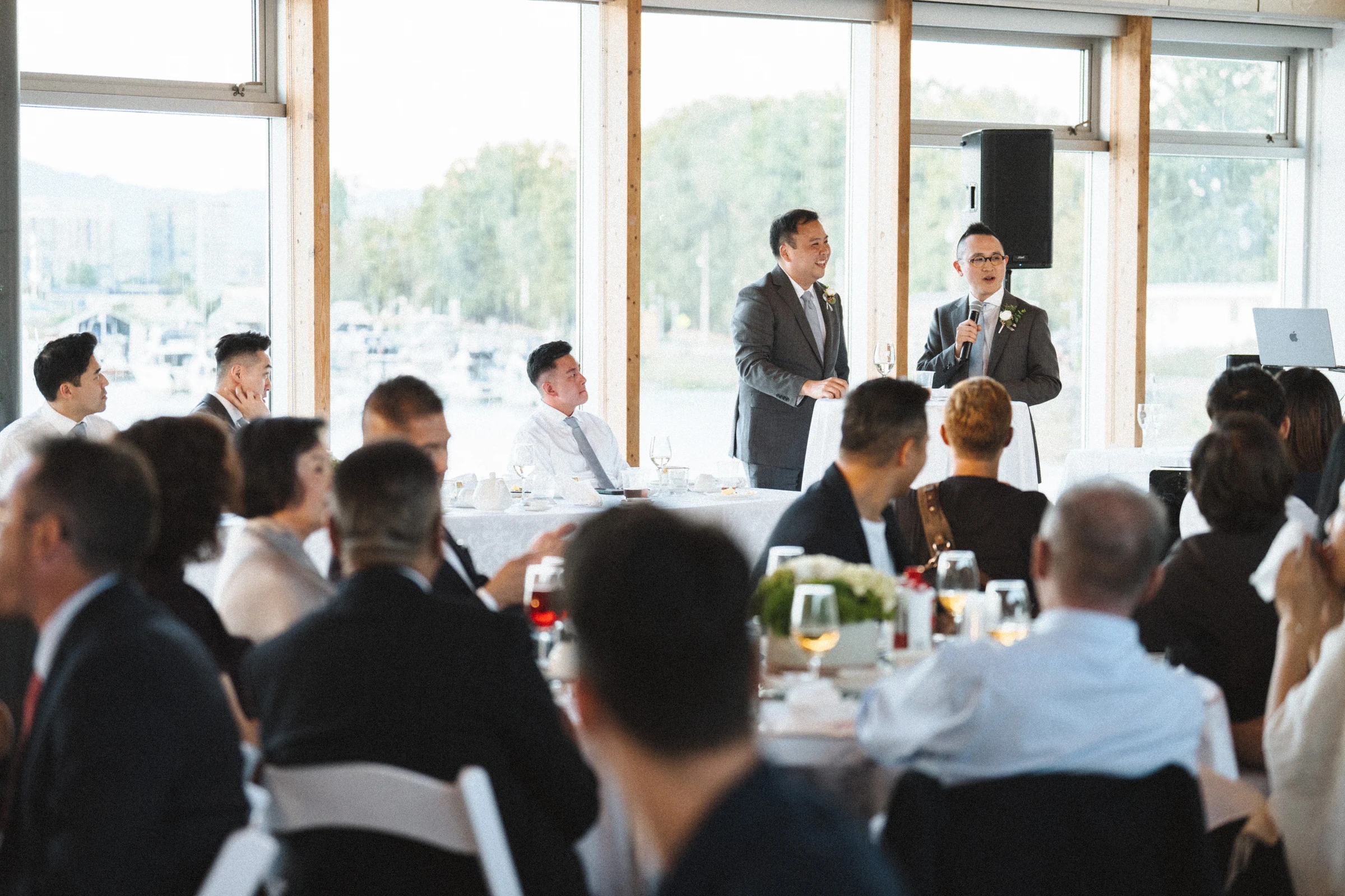 Guest giving a speech with a microphone beside the windows.