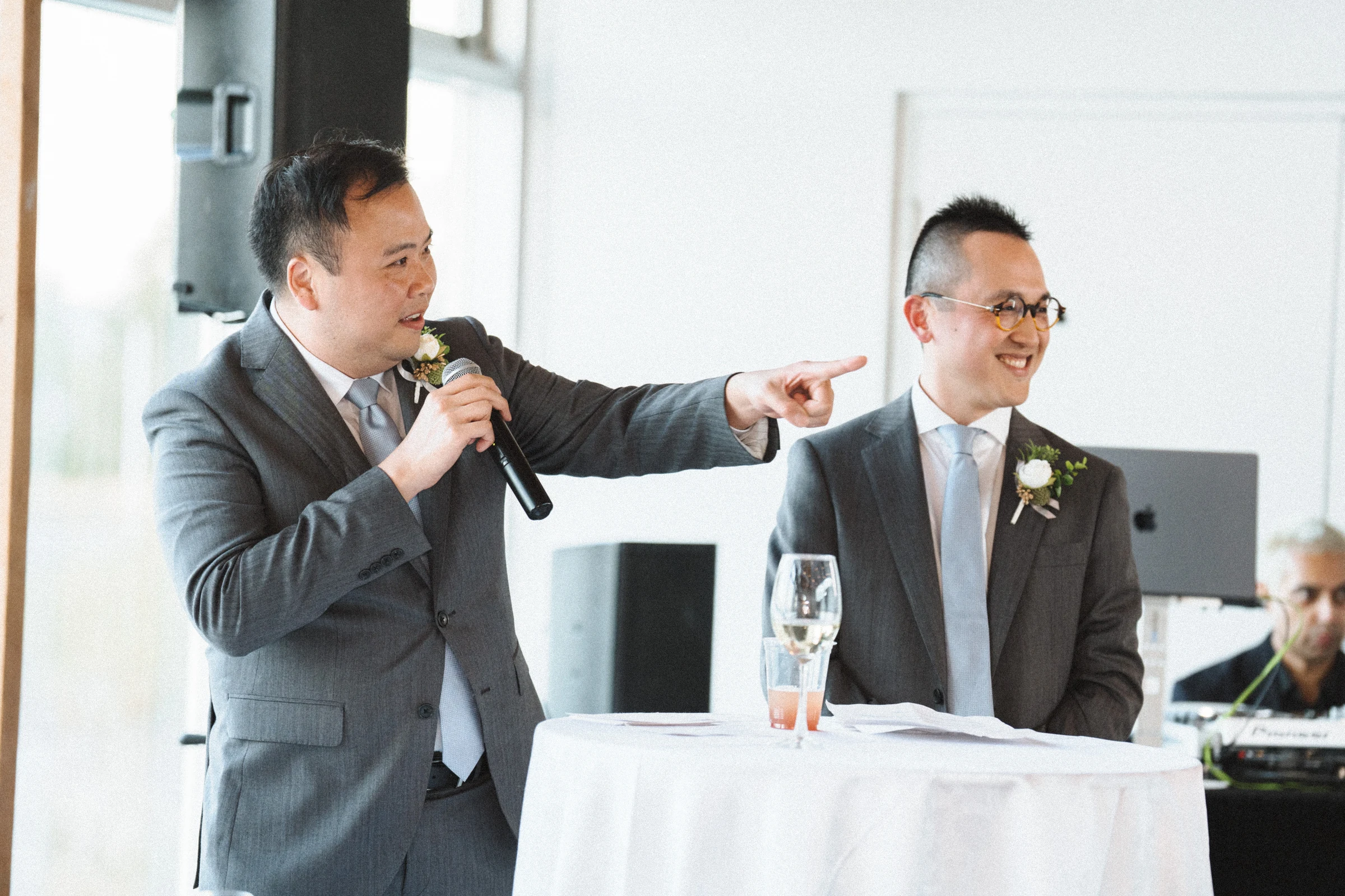 Two guests sharing a microphone during a reception speech.