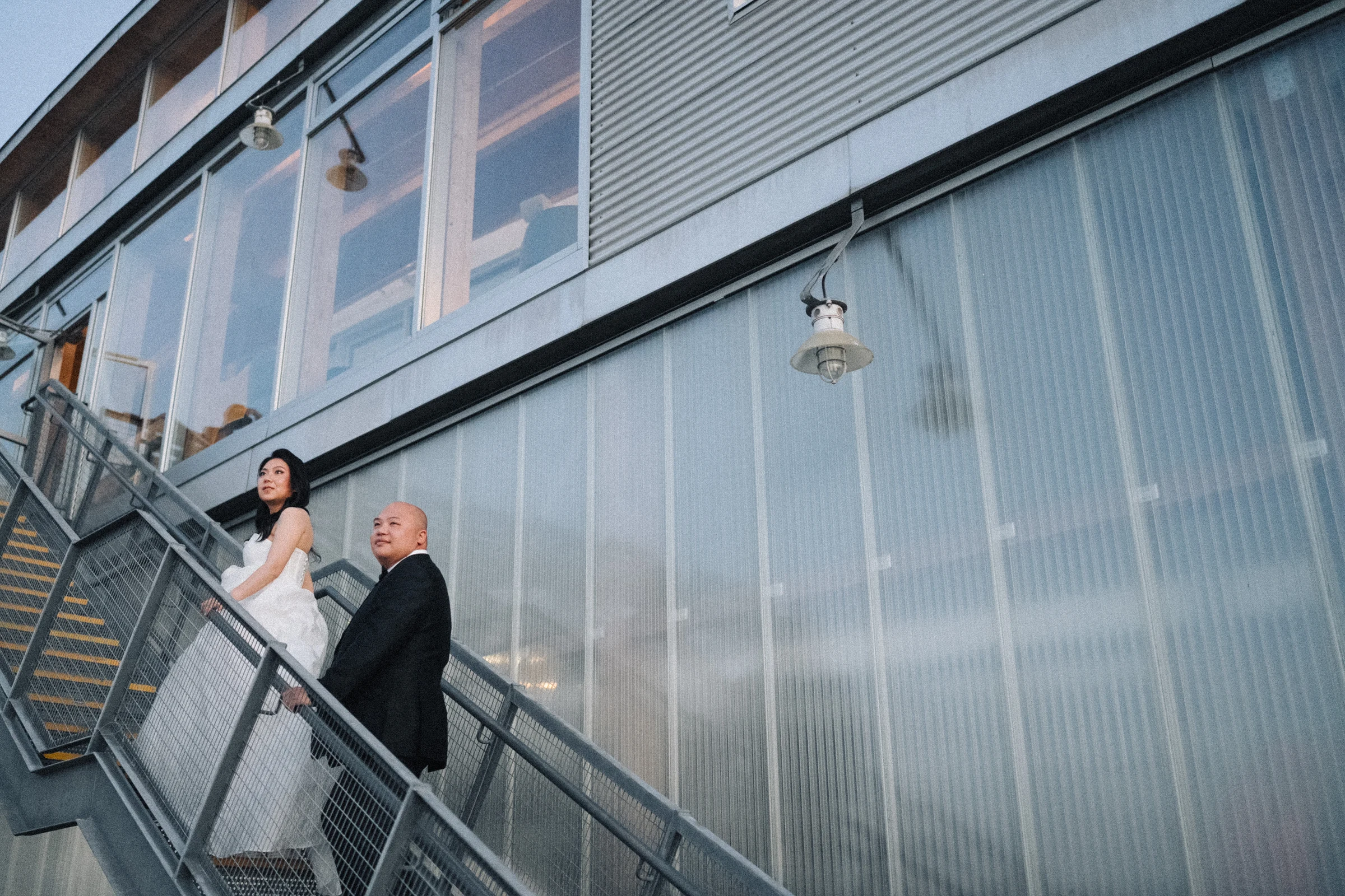 Groom looking back from the exterior staircase at dusk.