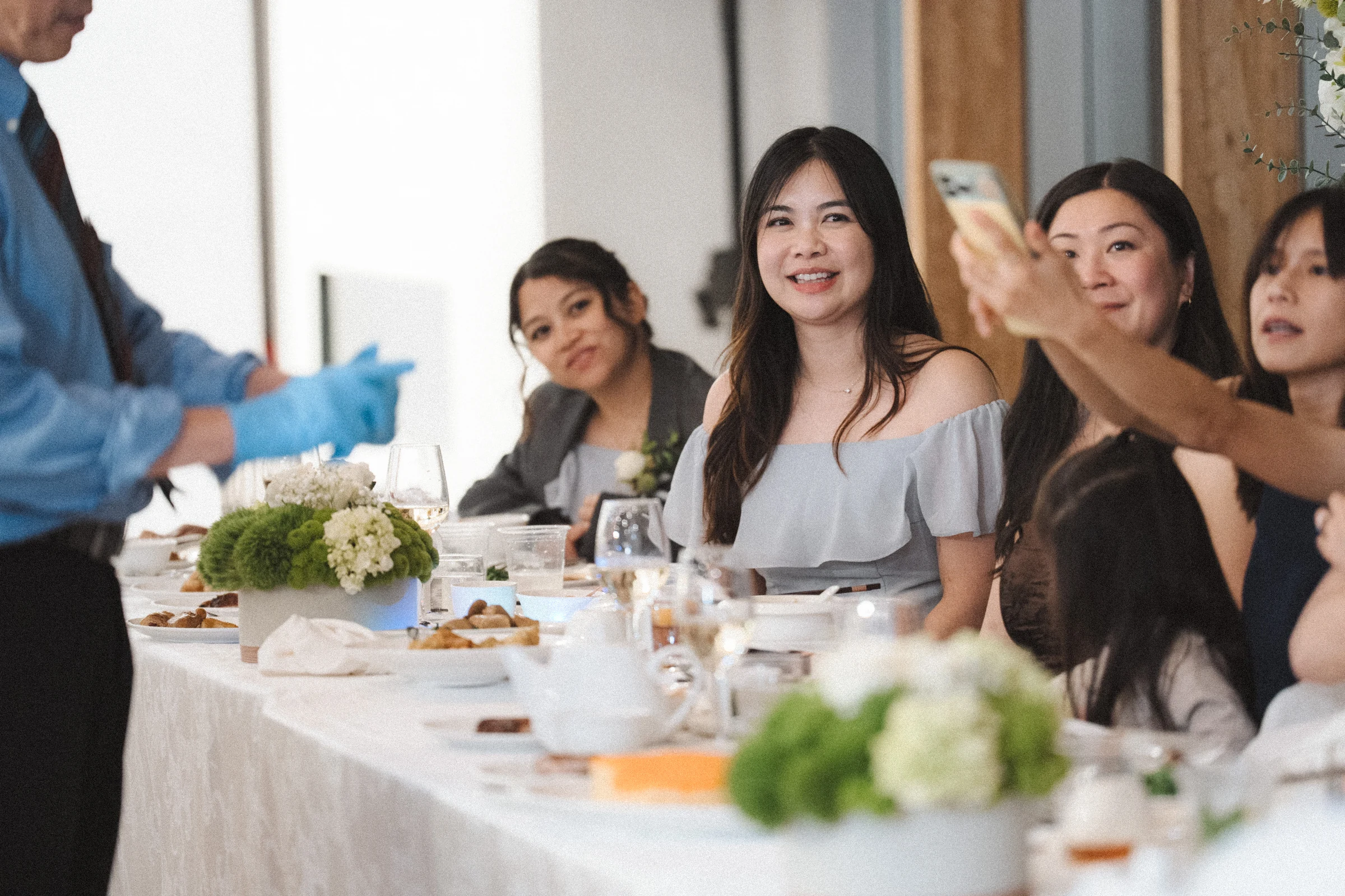Guests gesturing and smiling across the reception tables.
