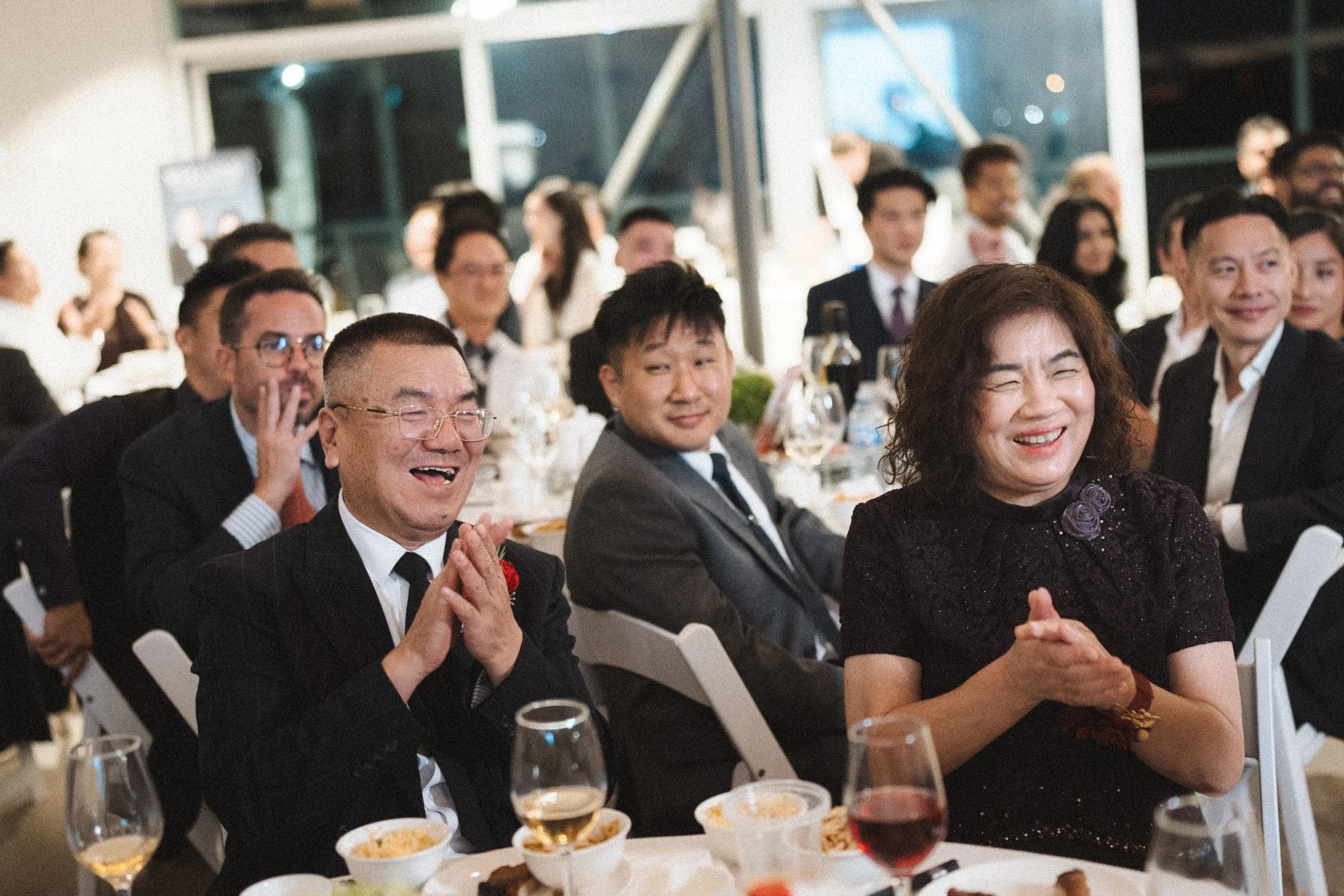Guests laughing together at a reception table.