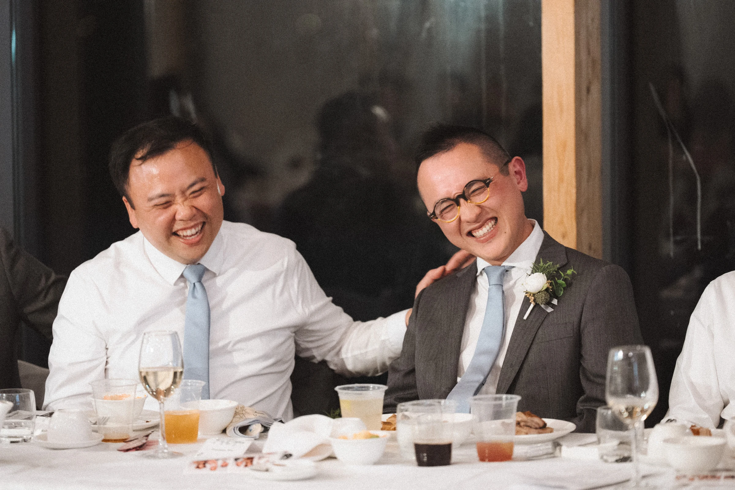 Two guests smiling towards each other across the table.