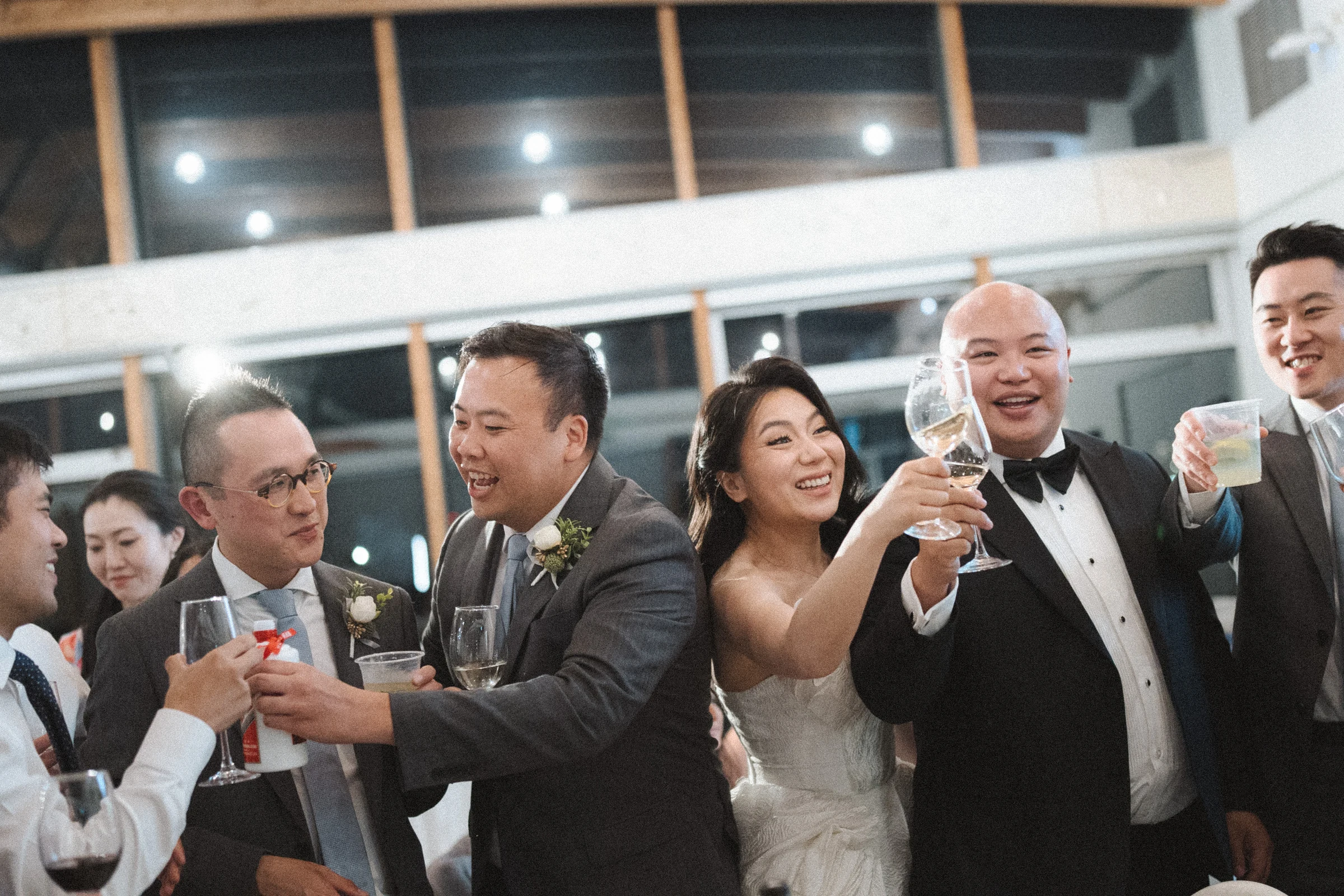 Guests joining a table toast with the couple.