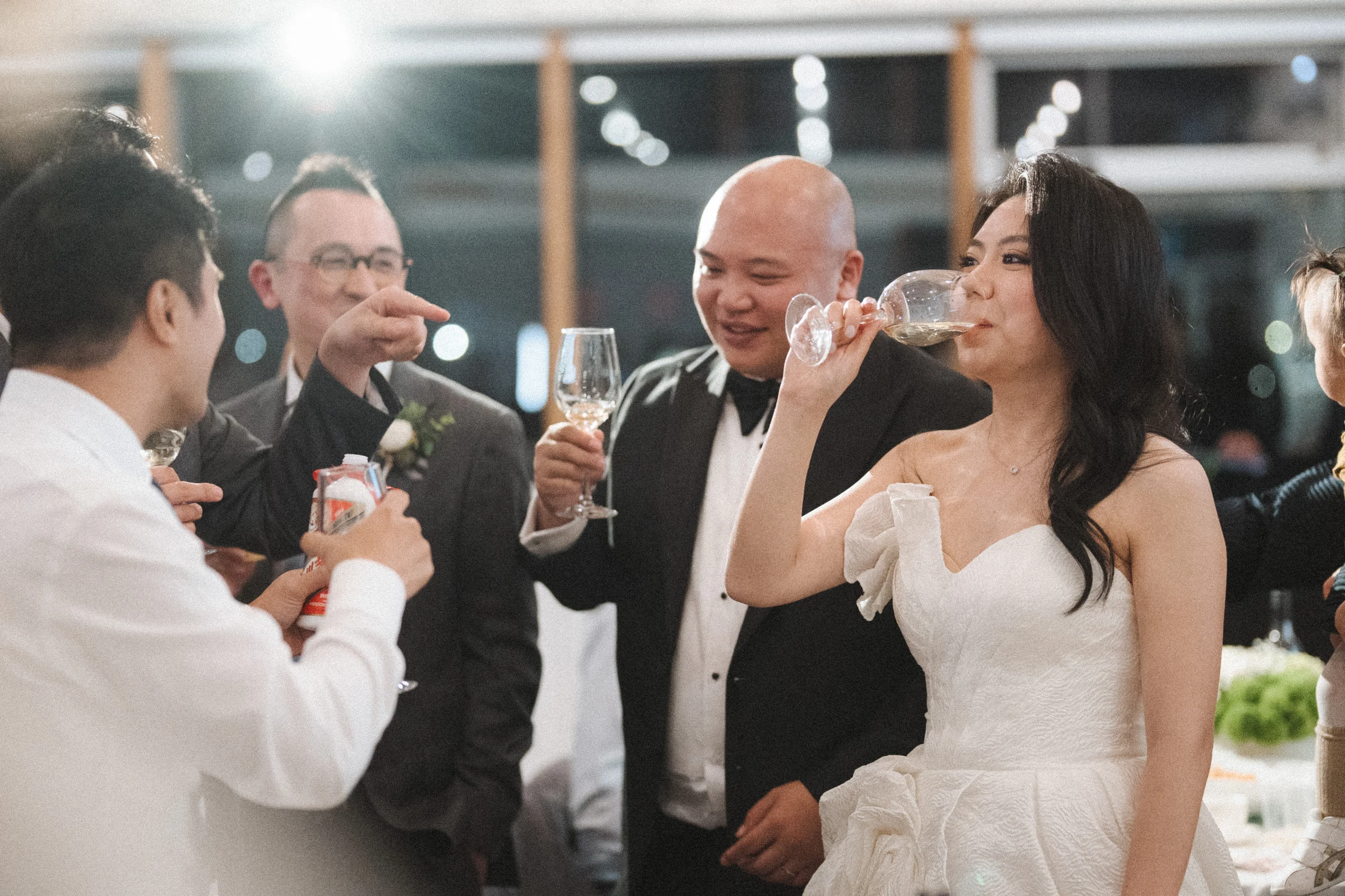 Bride and groom smiling as they lift their glasses.