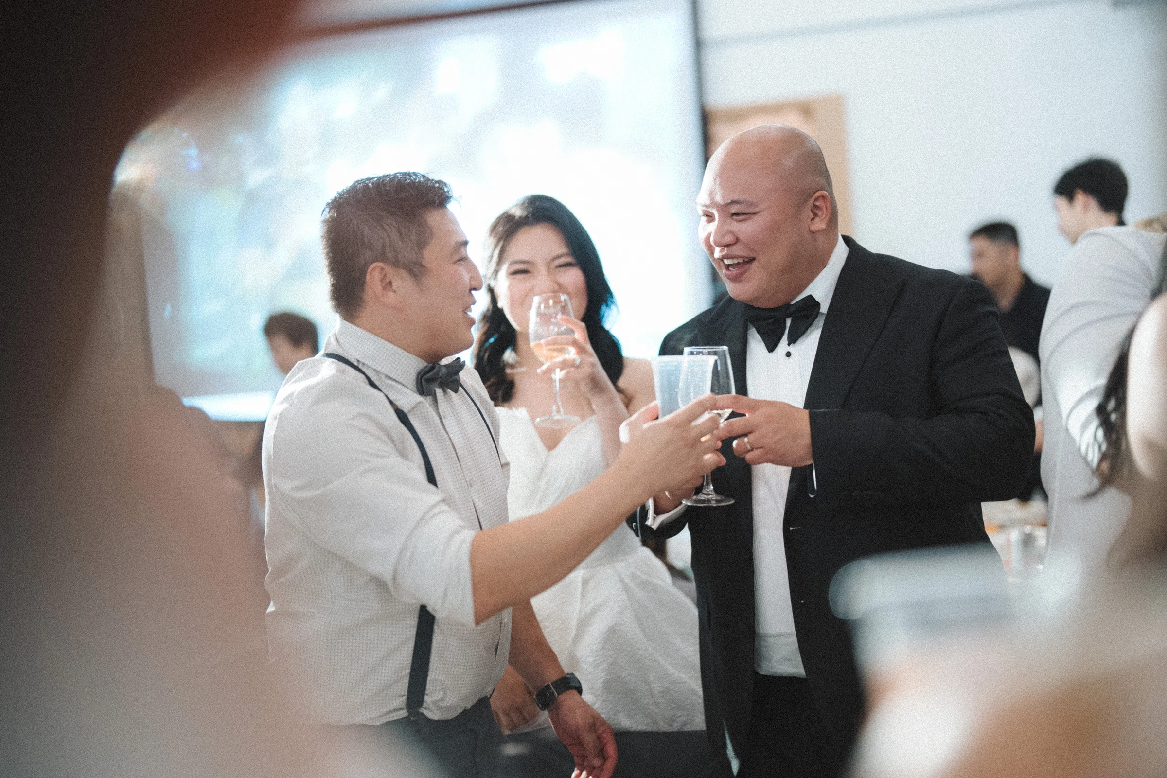 Guests holding up glasses beside the groom.