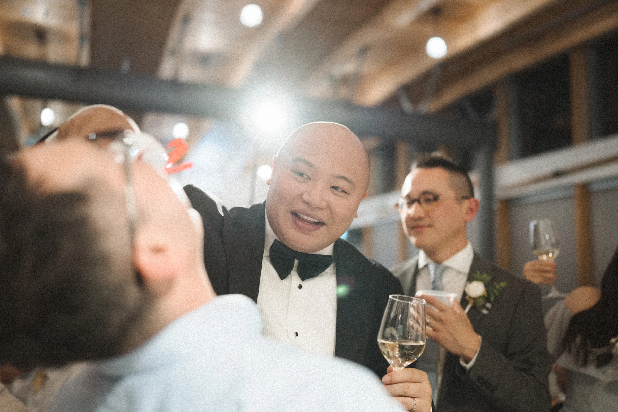 Groom laughing among friends during the evening toasts.