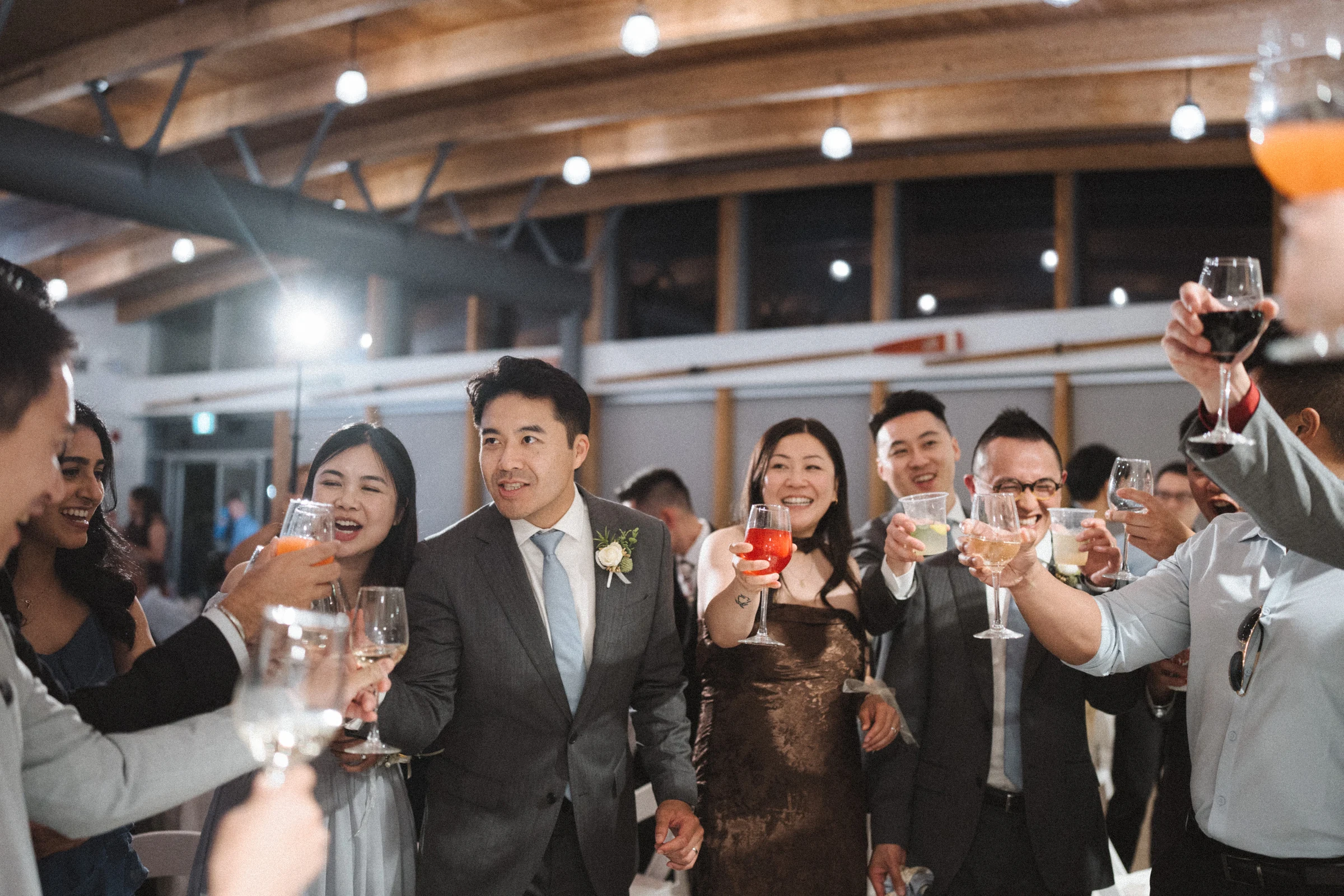Group of guests raising glasses towards the camera.