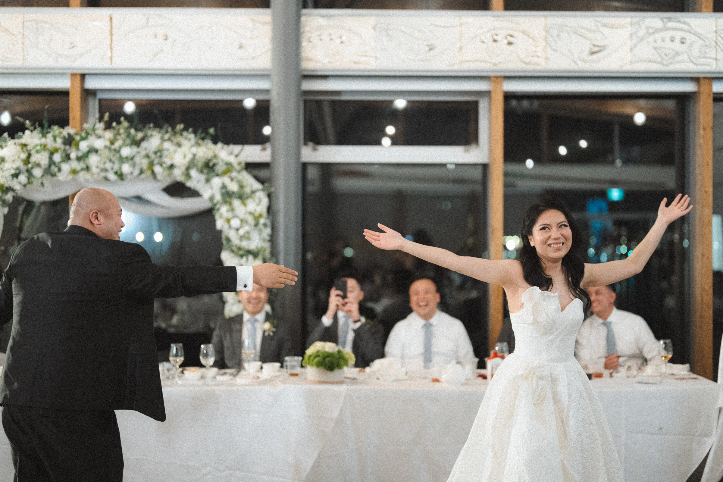 Couple opening their arms during a dance in the reception hall.