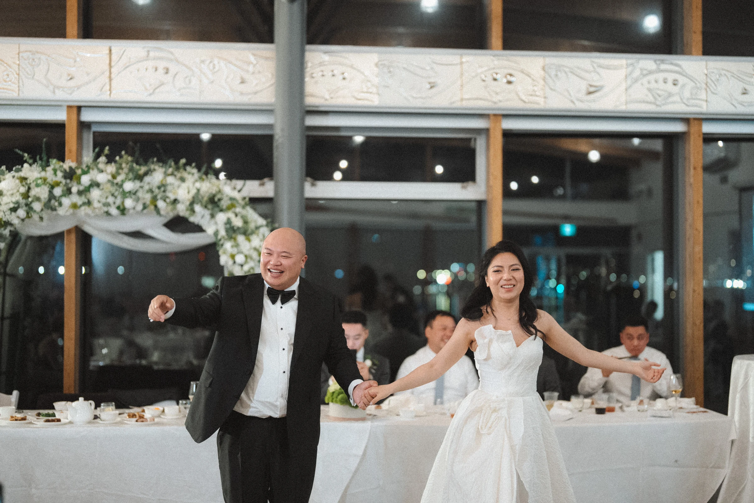 Couple smiling as they dance together in front of their guests.