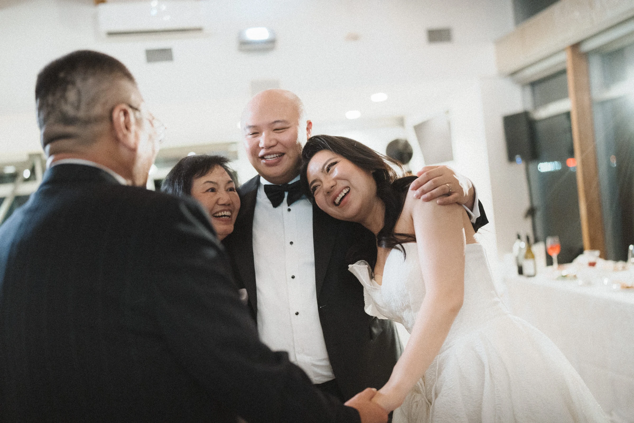 Guests leaning into a close, smiling group hug with the couple.