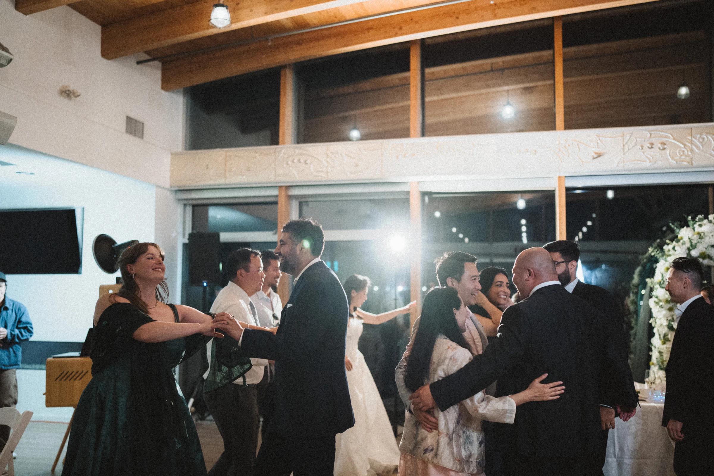 Guests embracing and dancing together in the reception hall.