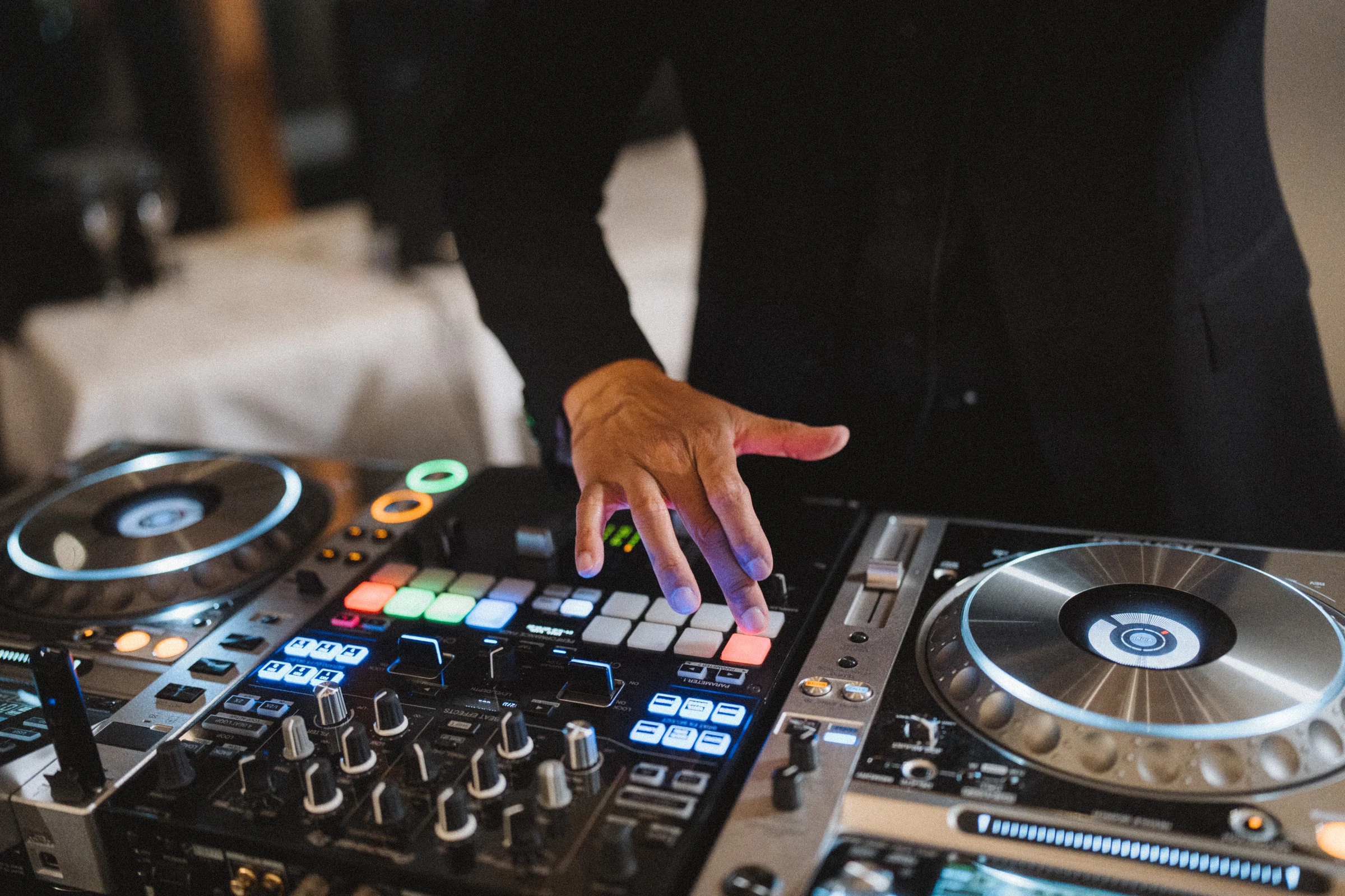 Close view of the DJ's hands on the mixing controls.