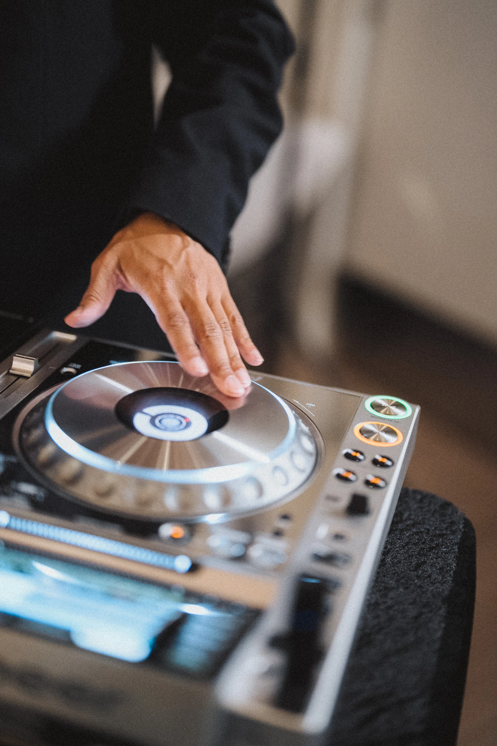 Close detail of a hand at the DJ controls.