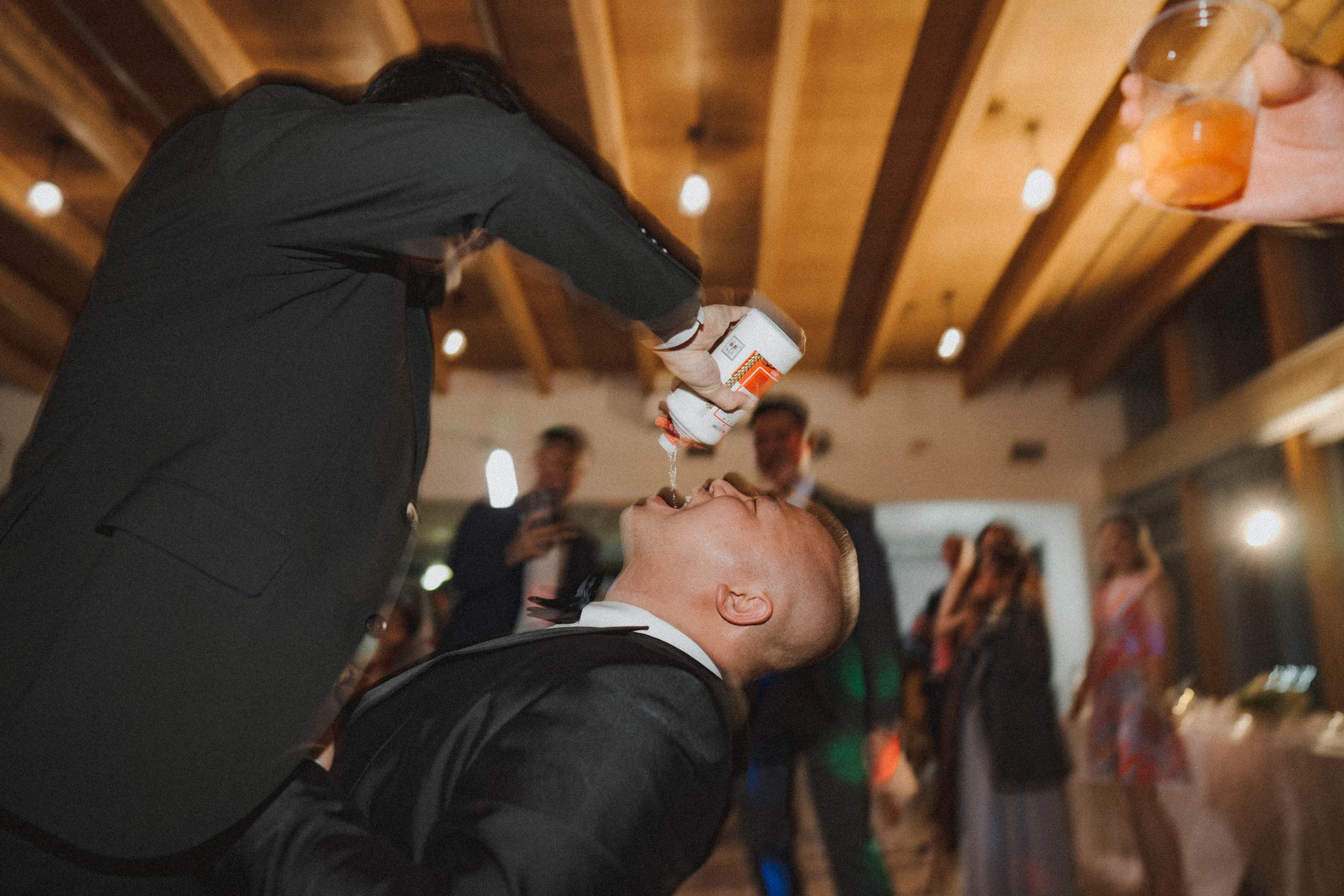 Guest tilting his head back during a playful reception celebration.