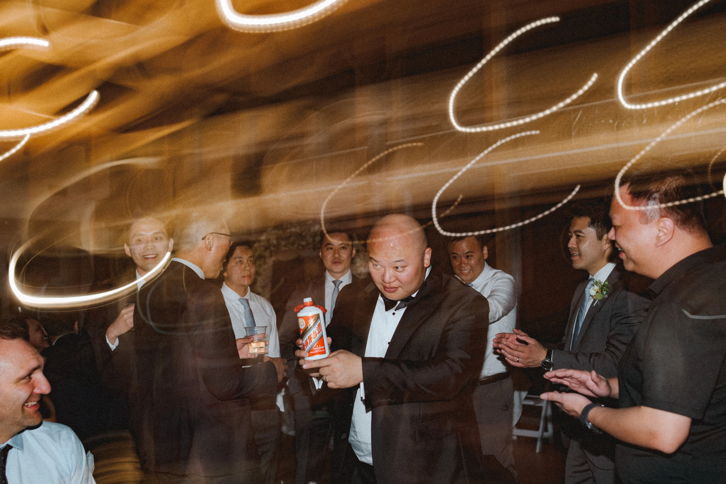 Guests moving together beneath loops of light on the dance floor.