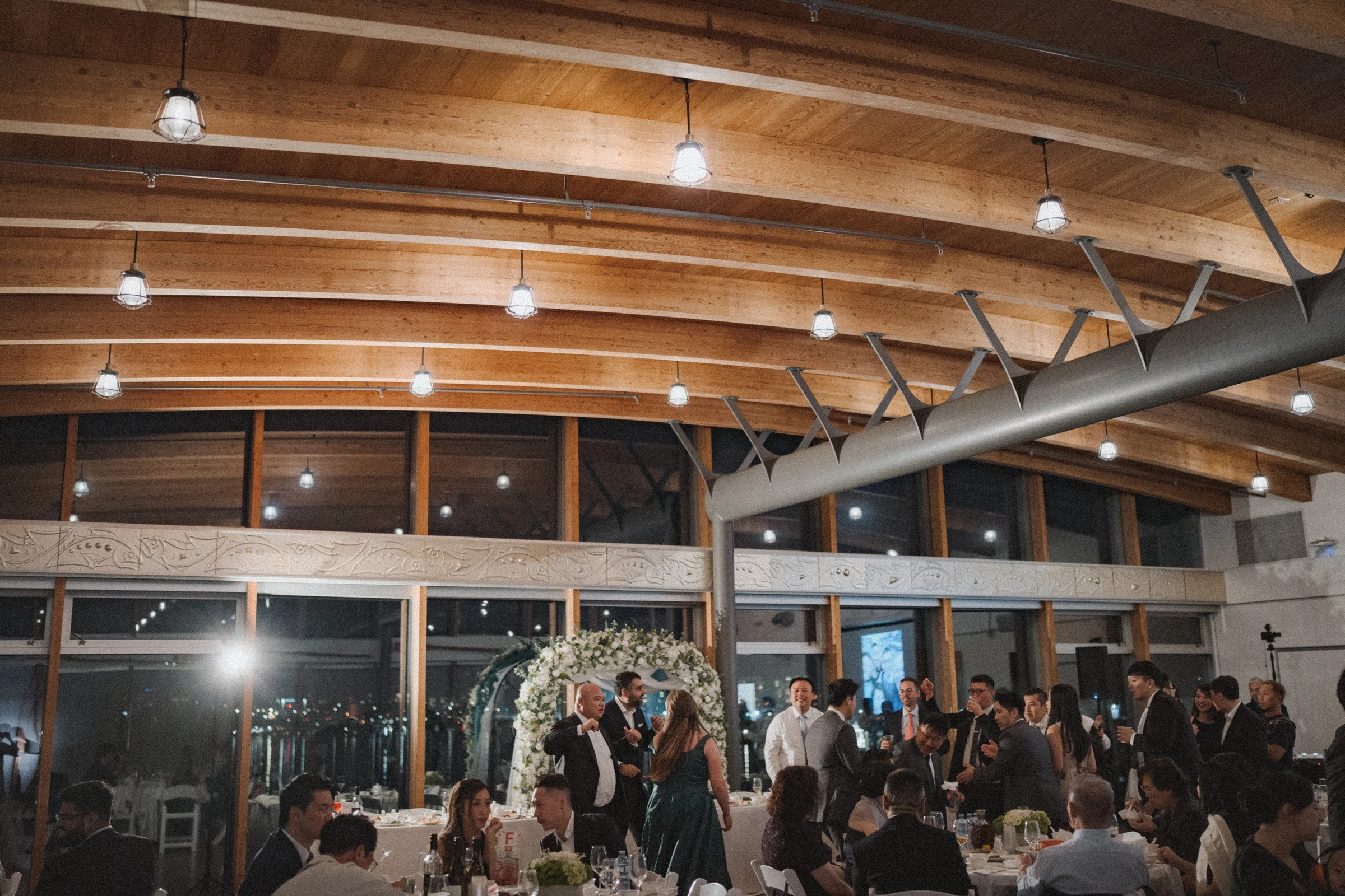 Wide view of the busy dance floor beneath the timber ceiling.