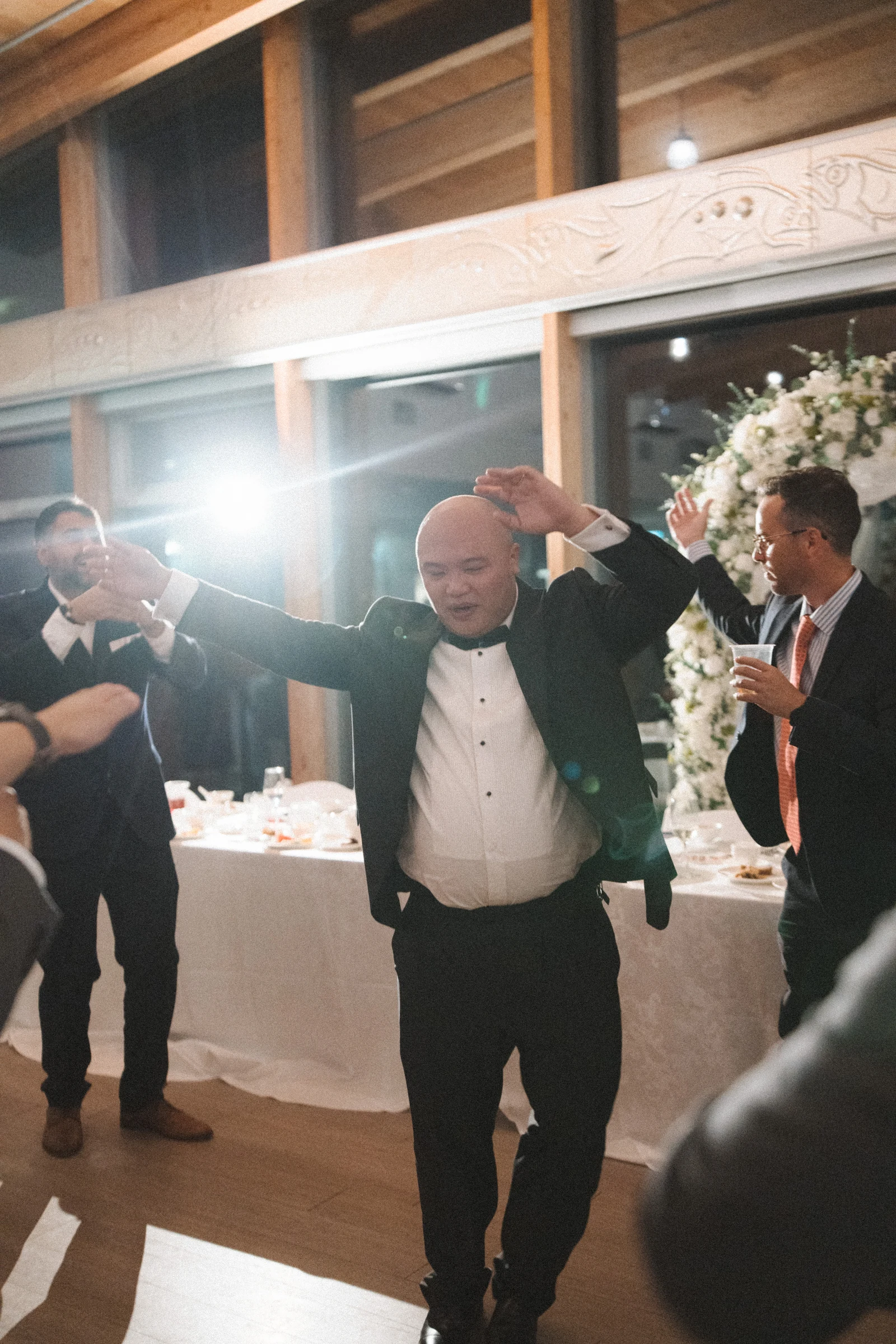 Groom raising his arms on the dance floor.