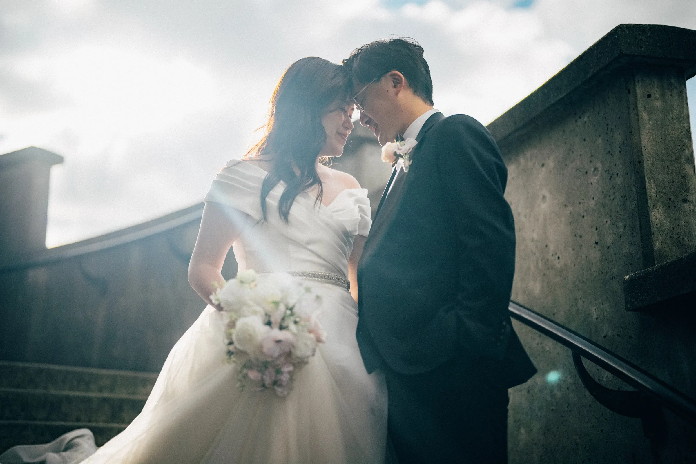 Couple intimate close-up on stairs, backlit, Stanley Park wedding portrait.