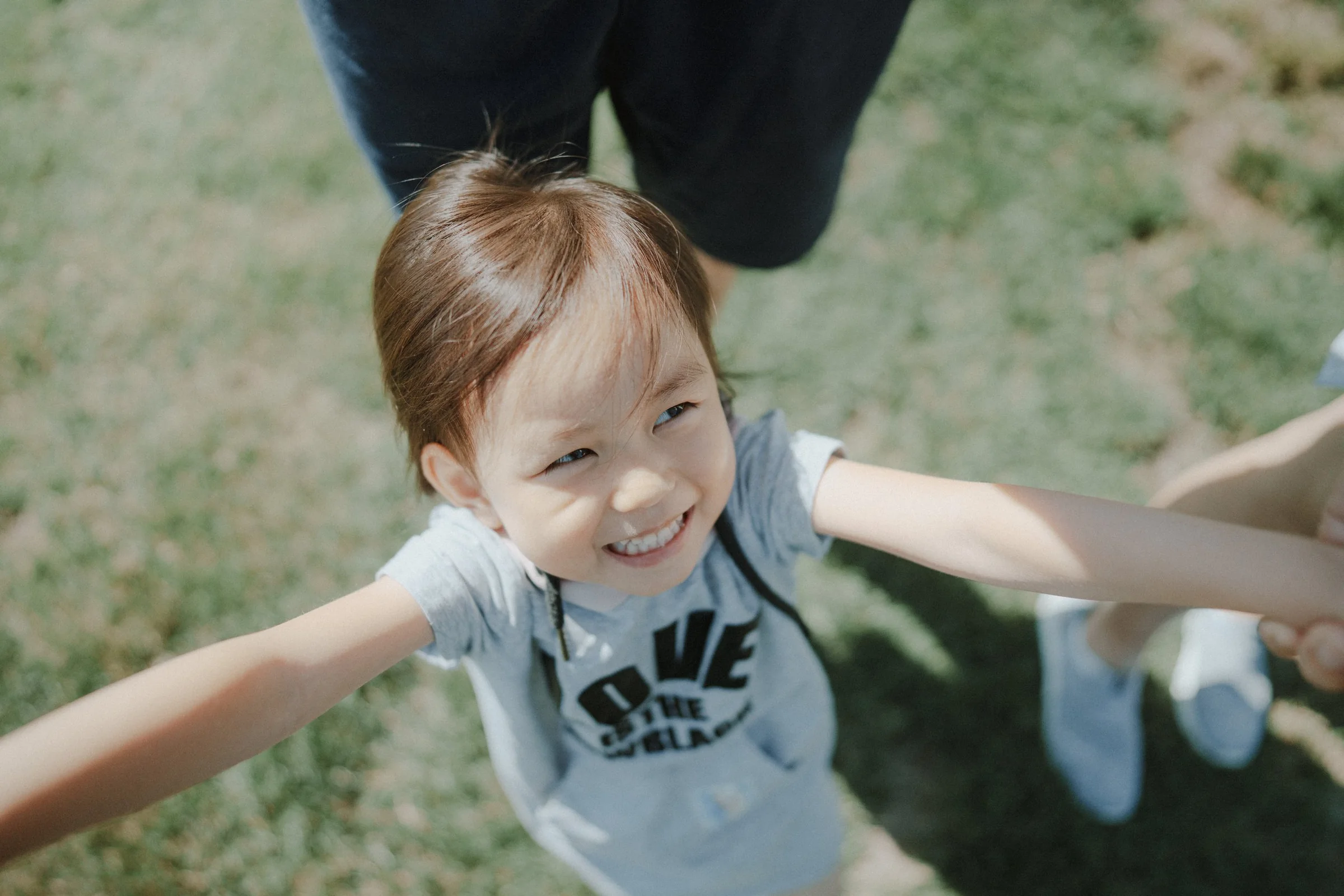 Child hugging adult’s arm outdoors at Richmond Country Farms