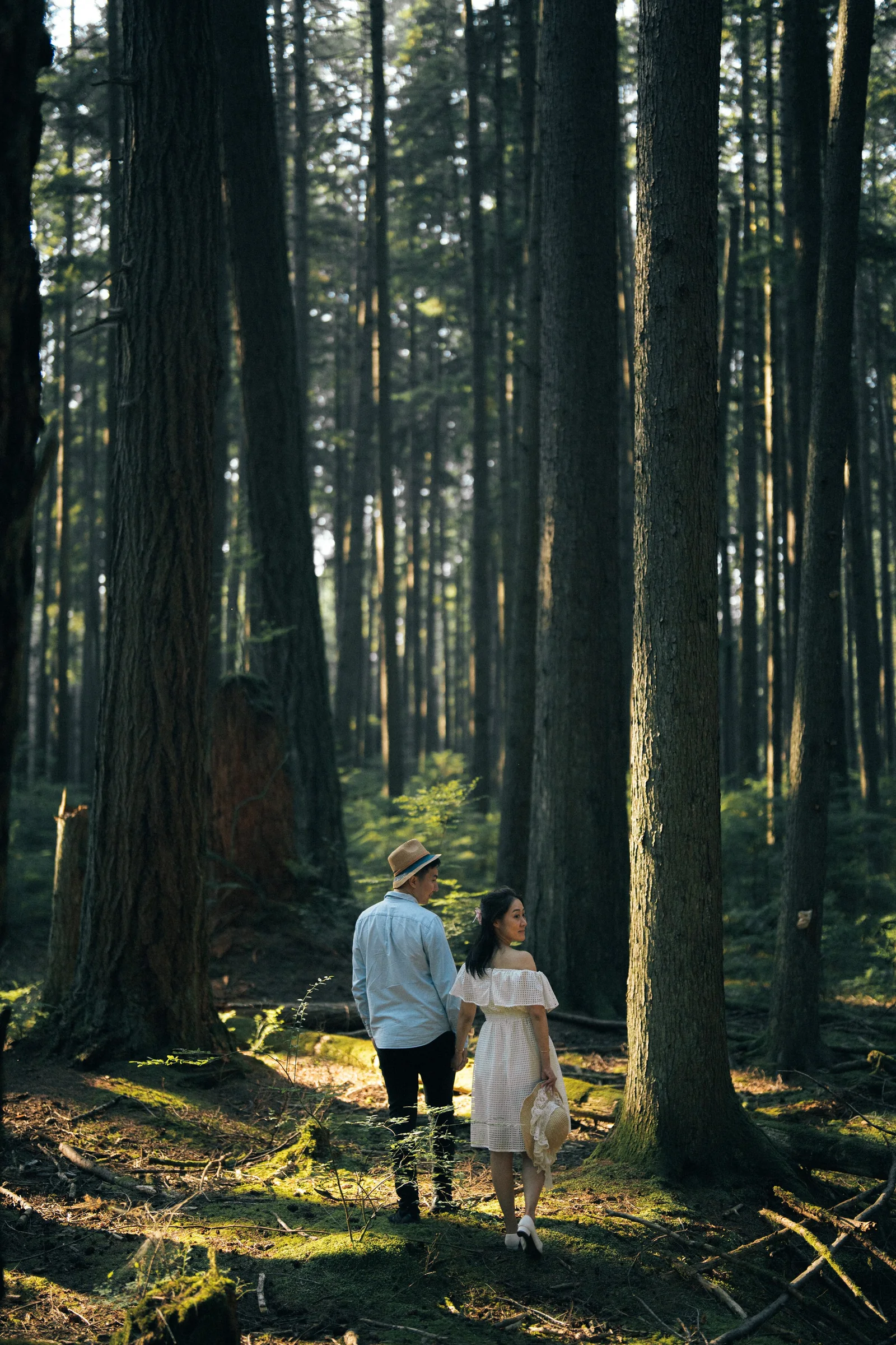 Couple walking away holding hands, deep forest Vancouver engagement photo.