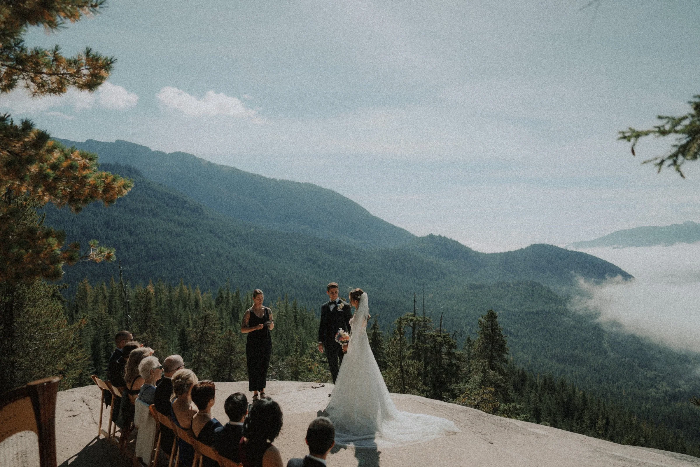 Wide view of the couple, officiant and guests at the mountain ceremony.