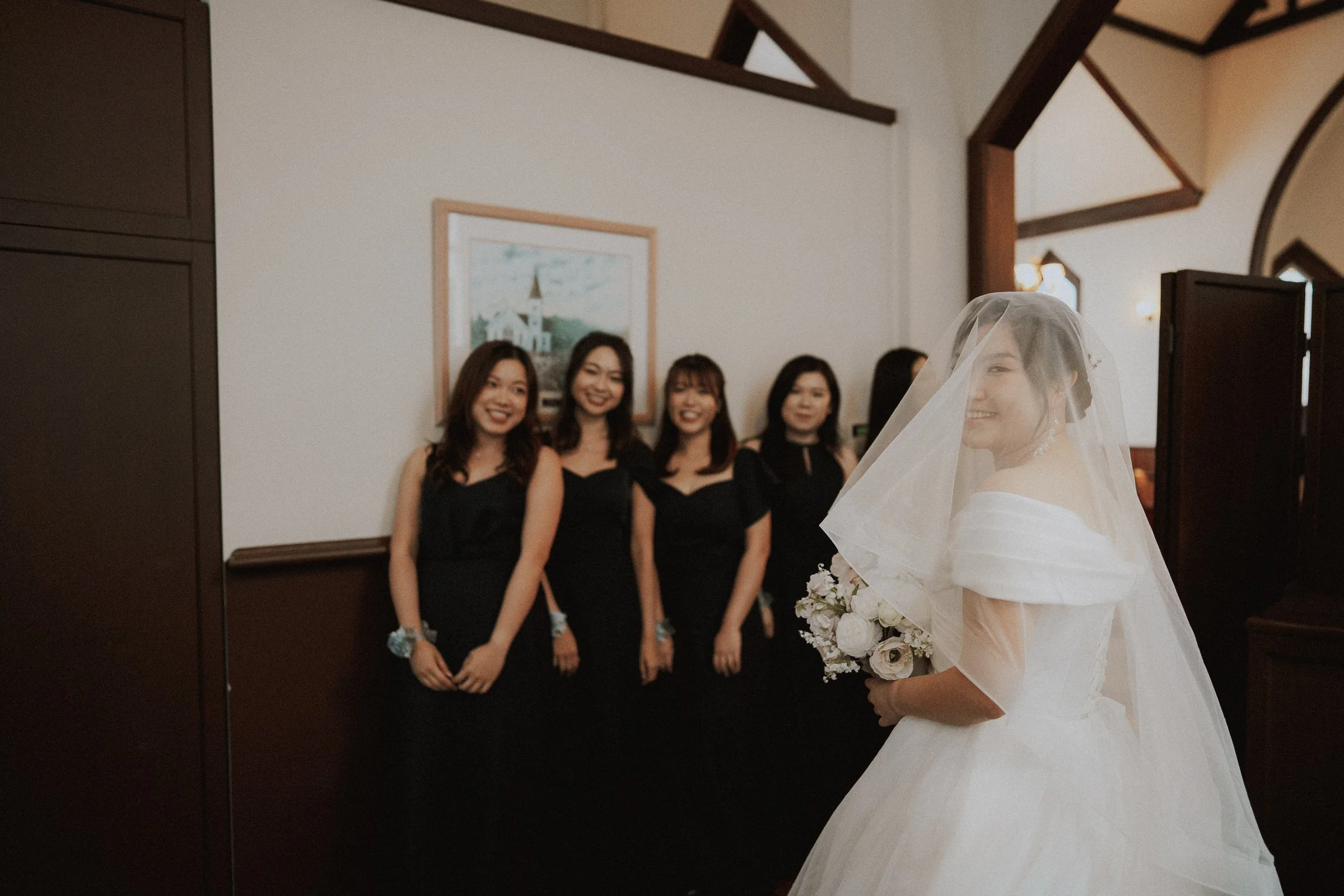 Bride glancing back toward bridesmaids before entering the ceremony.